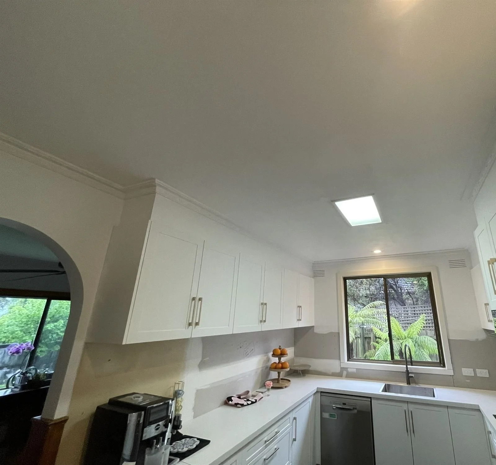 Freshly painted kitchen walls and ceiling above white cabinetry