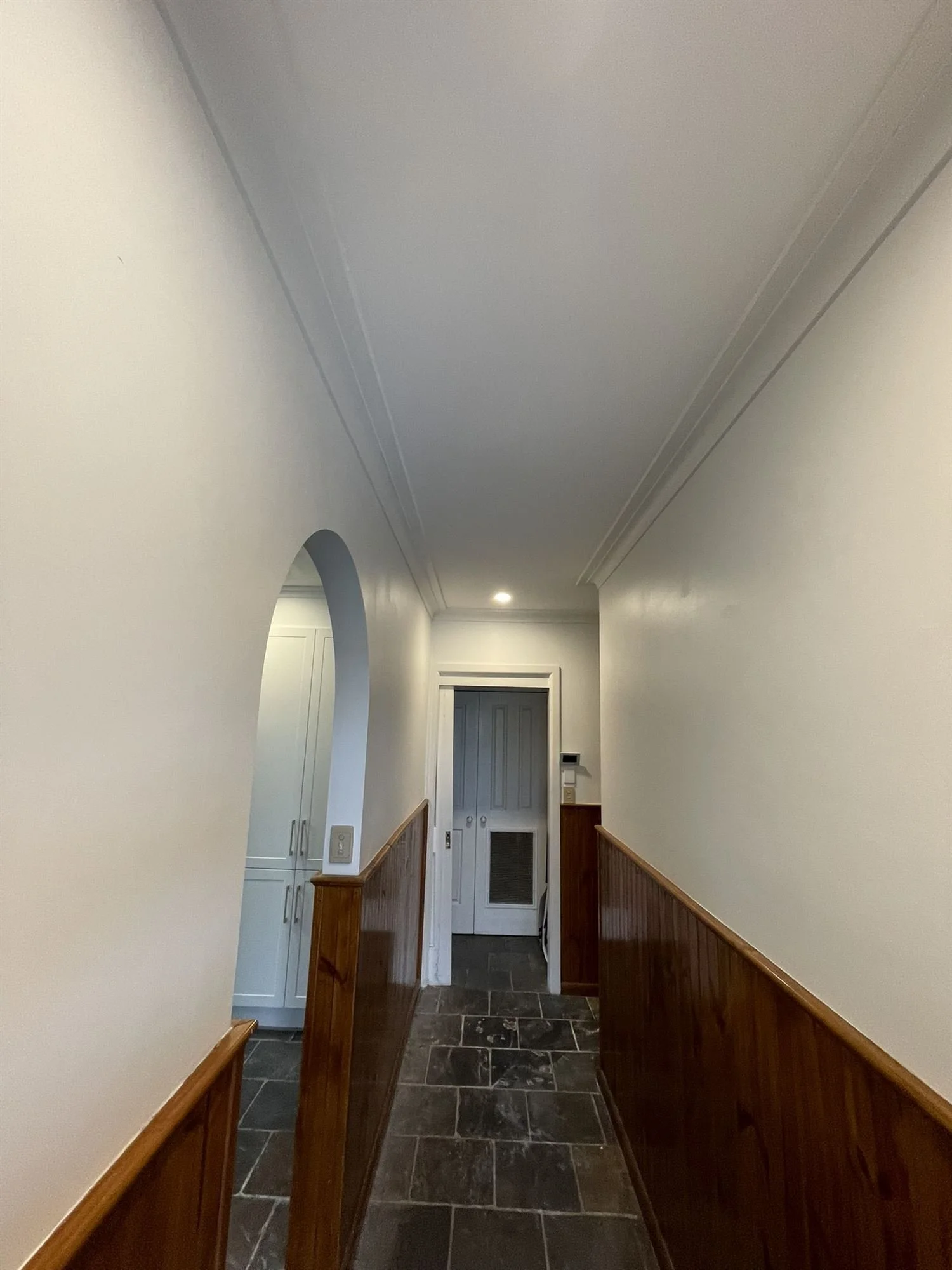 Freshly painted hallway walls above timber panelling