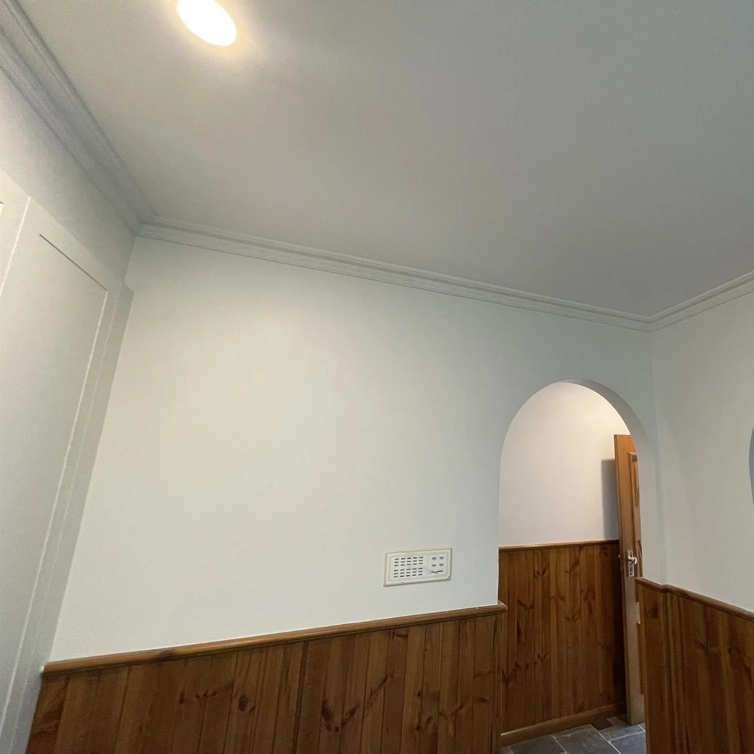 Freshly painted walls and arches above timber wall panelling