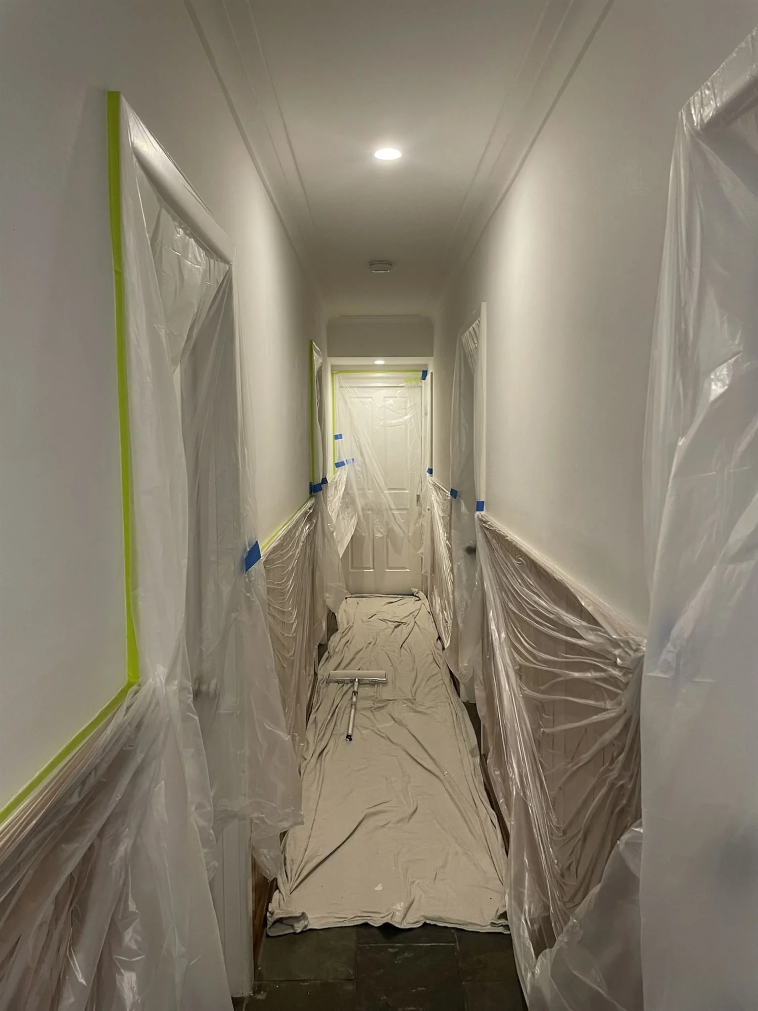 Hallway with floors and timber panelling protected before painting