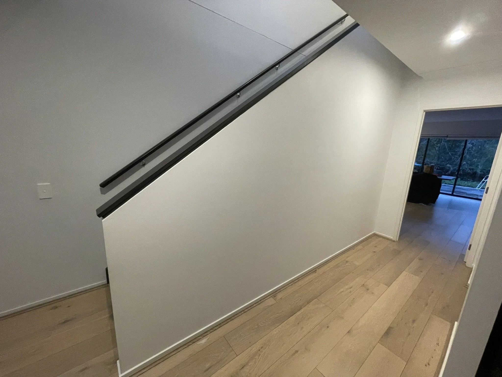 Freshly painted white stairwell and hallway with timber flooring, Croydon