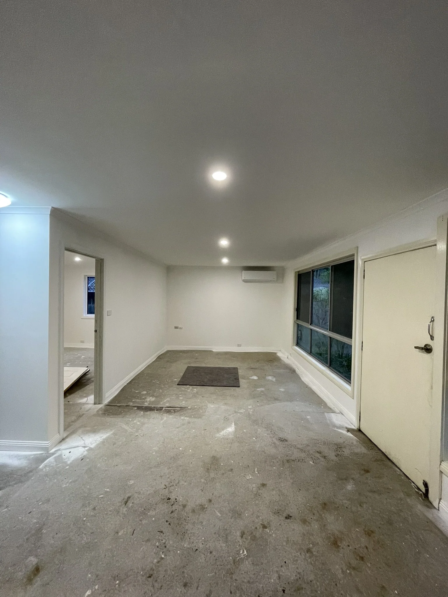 Long open room in a new house extension with freshly painted white walls and ceiling