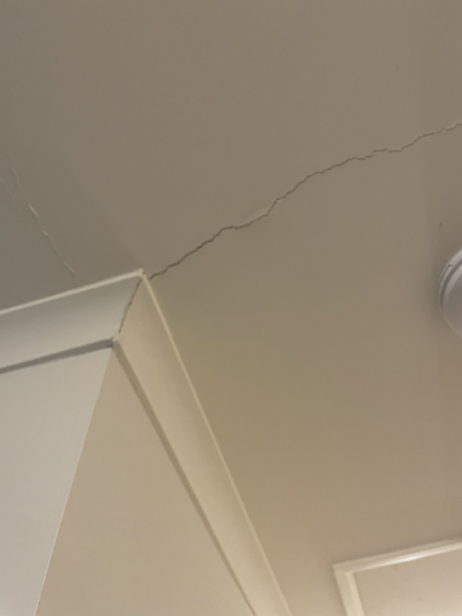 Crack running across a ceiling corner before repair