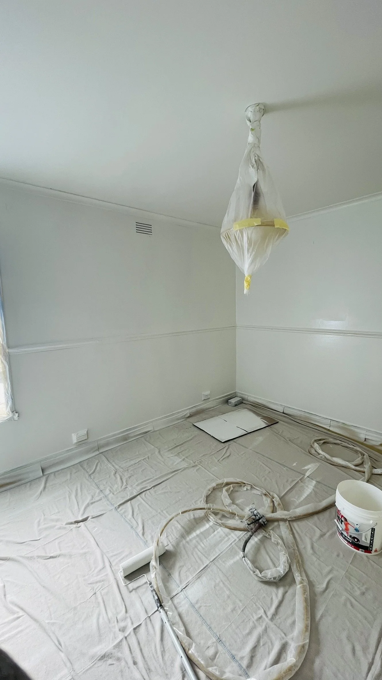 Freshly painted white room with floor protection still in place