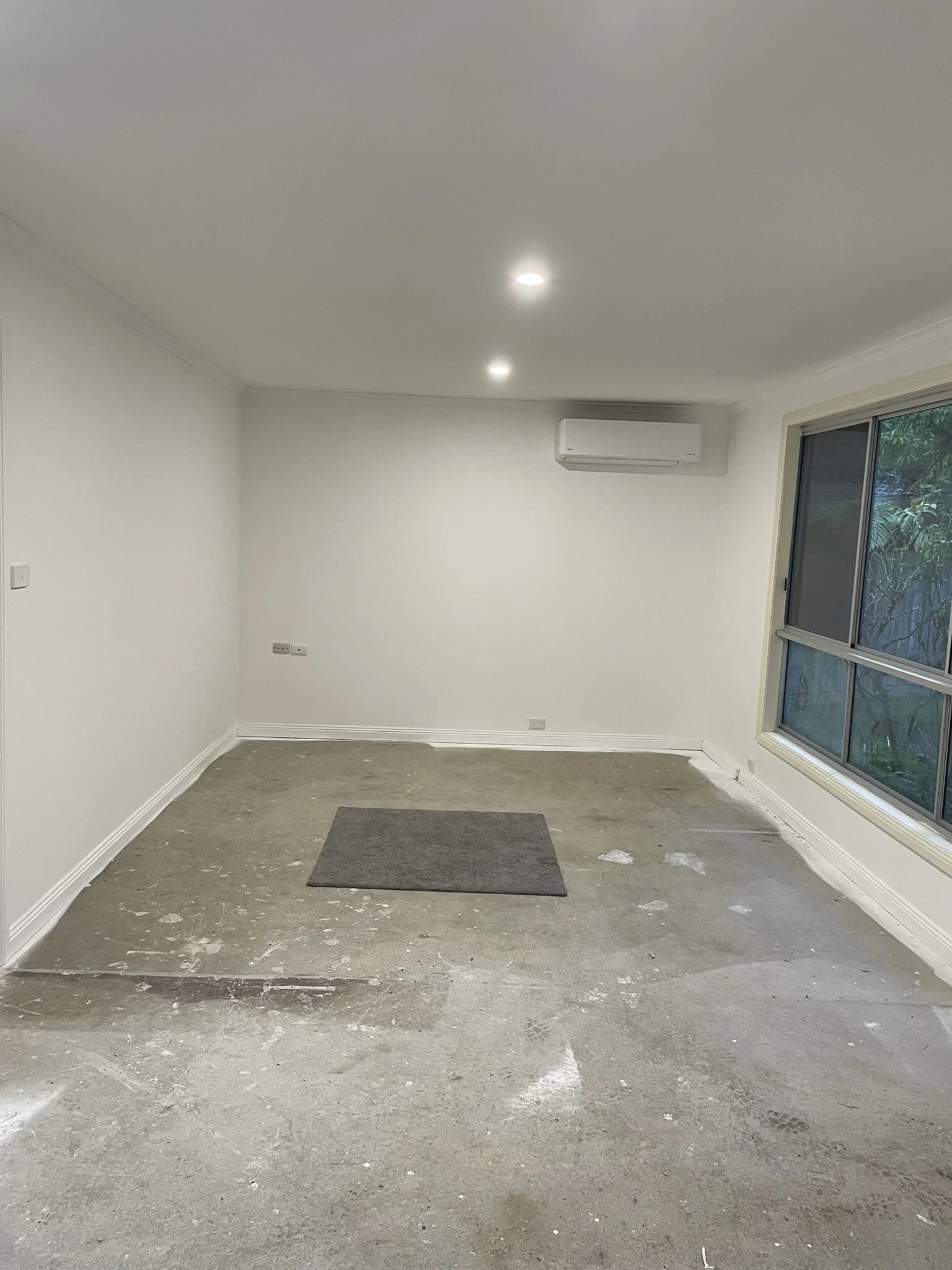 Painted room in a house extension with white walls, ceiling and air conditioner