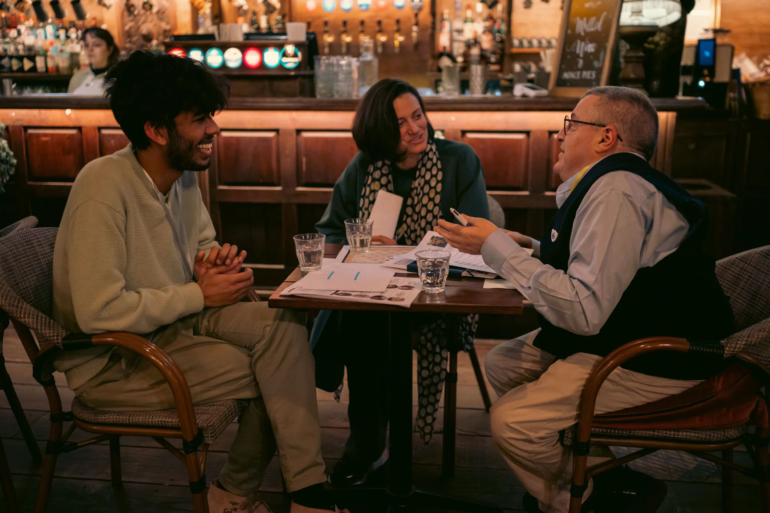 Two men sat at a table talking excitedly.