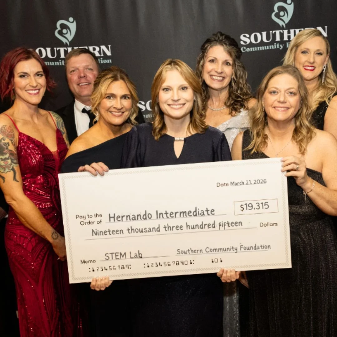 Group of seven people dressed in formal attire, holding a large check for $19,315 made out to Hernando Intermediate, presented by Southern Community Foundation at an event.
