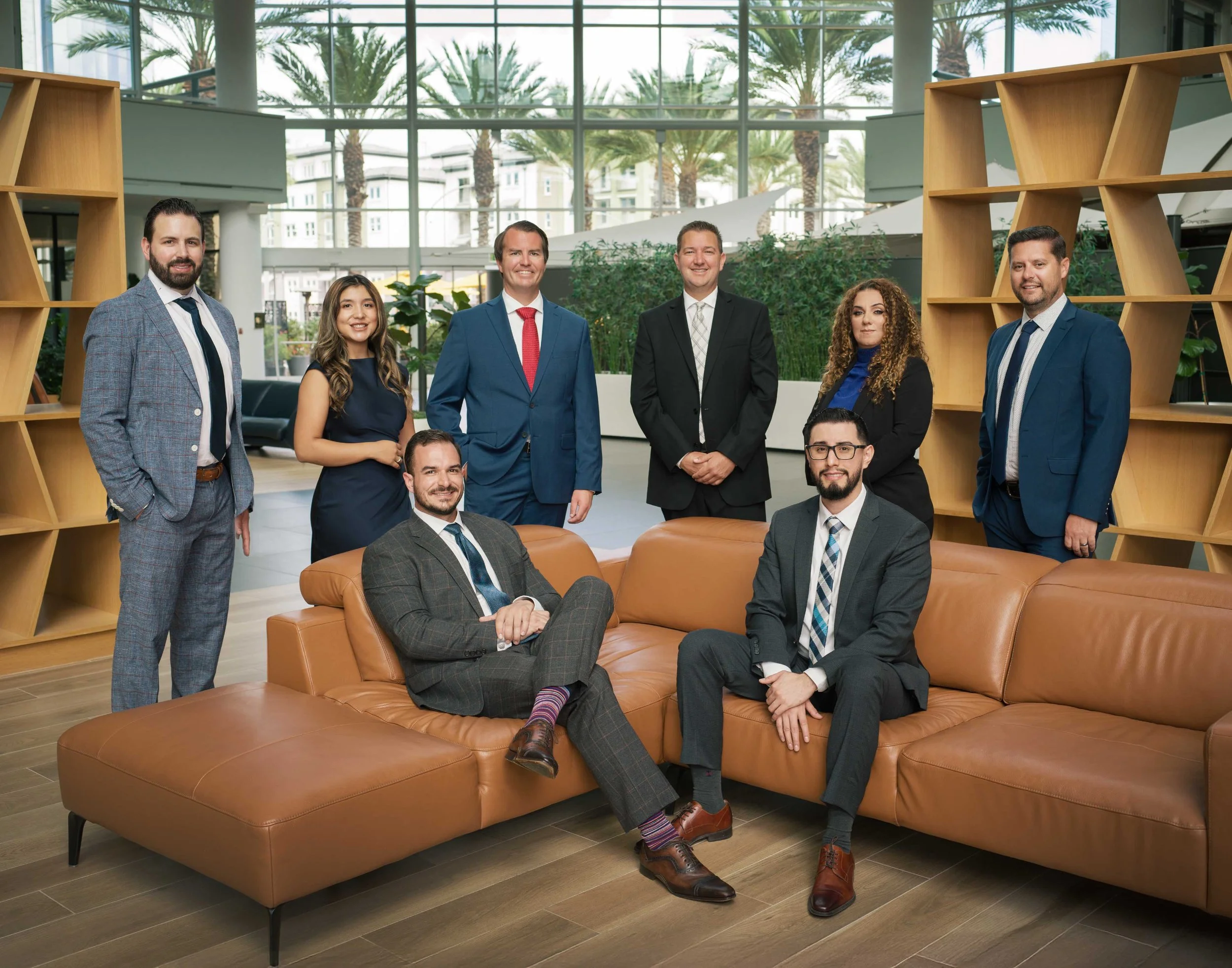 This business branding photography session highlights corporate professionalism with a fresh, modern edge. The financial advisors and wealth management professionals are photographed in a clean, upscale workspace featuring glass conference rooms, war