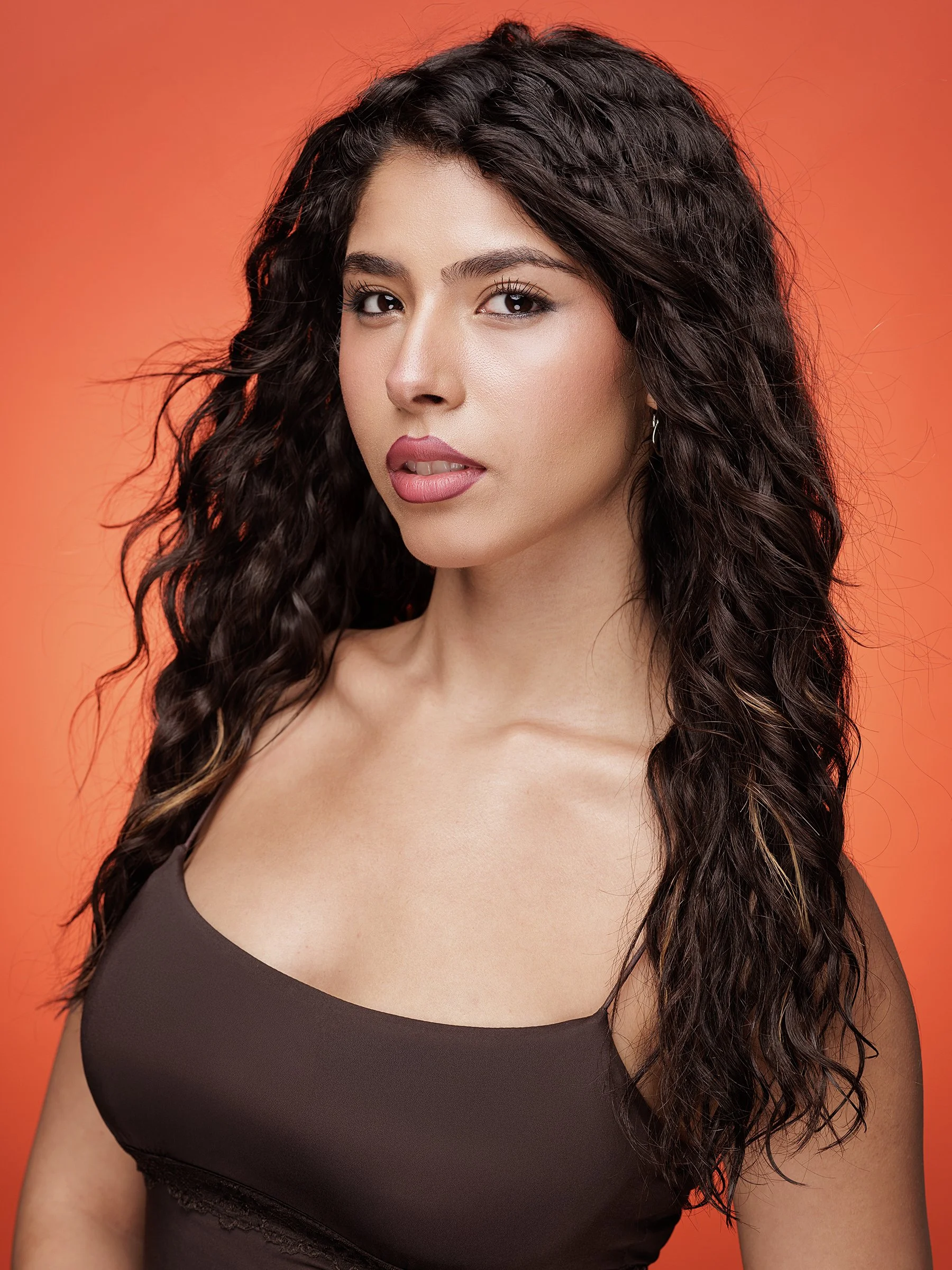 A dramatic theatrical portrait featuring the actor with textured, slightly tousled hair for a brooding, cinematic feel. Shot against a dramatic seamless backdrop with directional lighting, the expression is intense and emotionally layered — ideal for