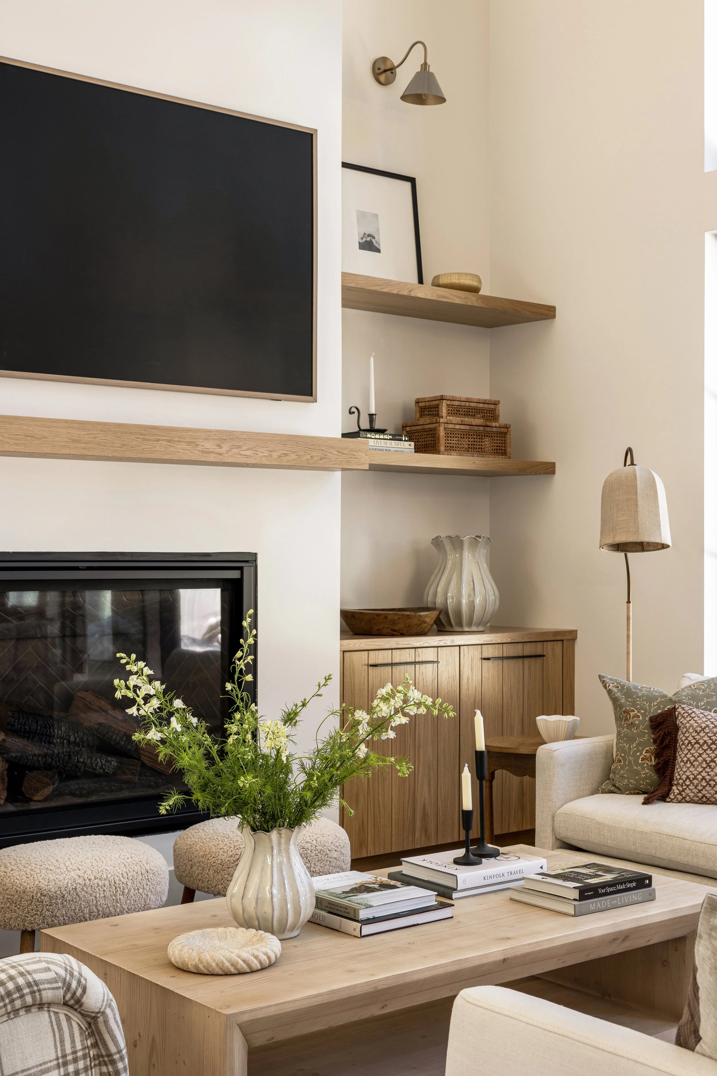 Cozy living room with white oak built-ins, sofa and boucle ottoman, styling on shelves