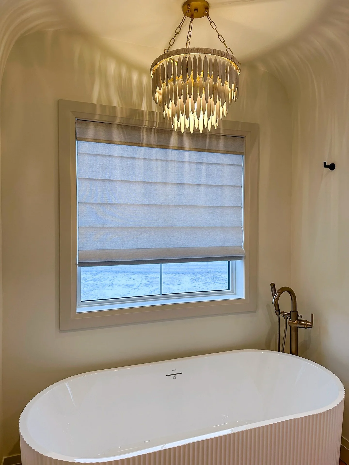 The finishing touch makes the whole room.

This bathroom already had the statement tub and chandelier, but the window needed something soft, clean, and functional.

We installed a Graber Cordless Roman Shade in Fresco, giving the space privacy withou