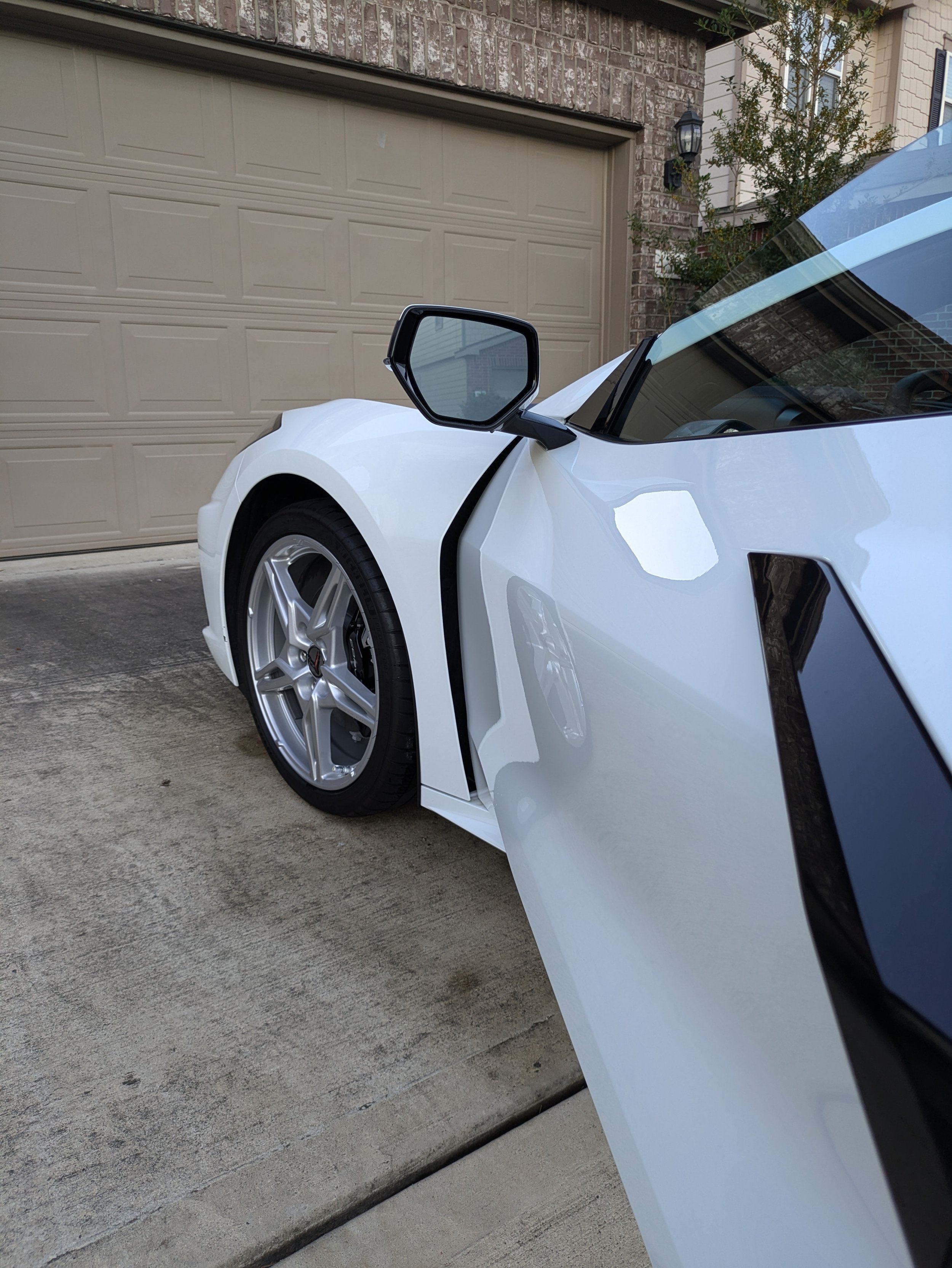 White sports car parked in front of a garage
