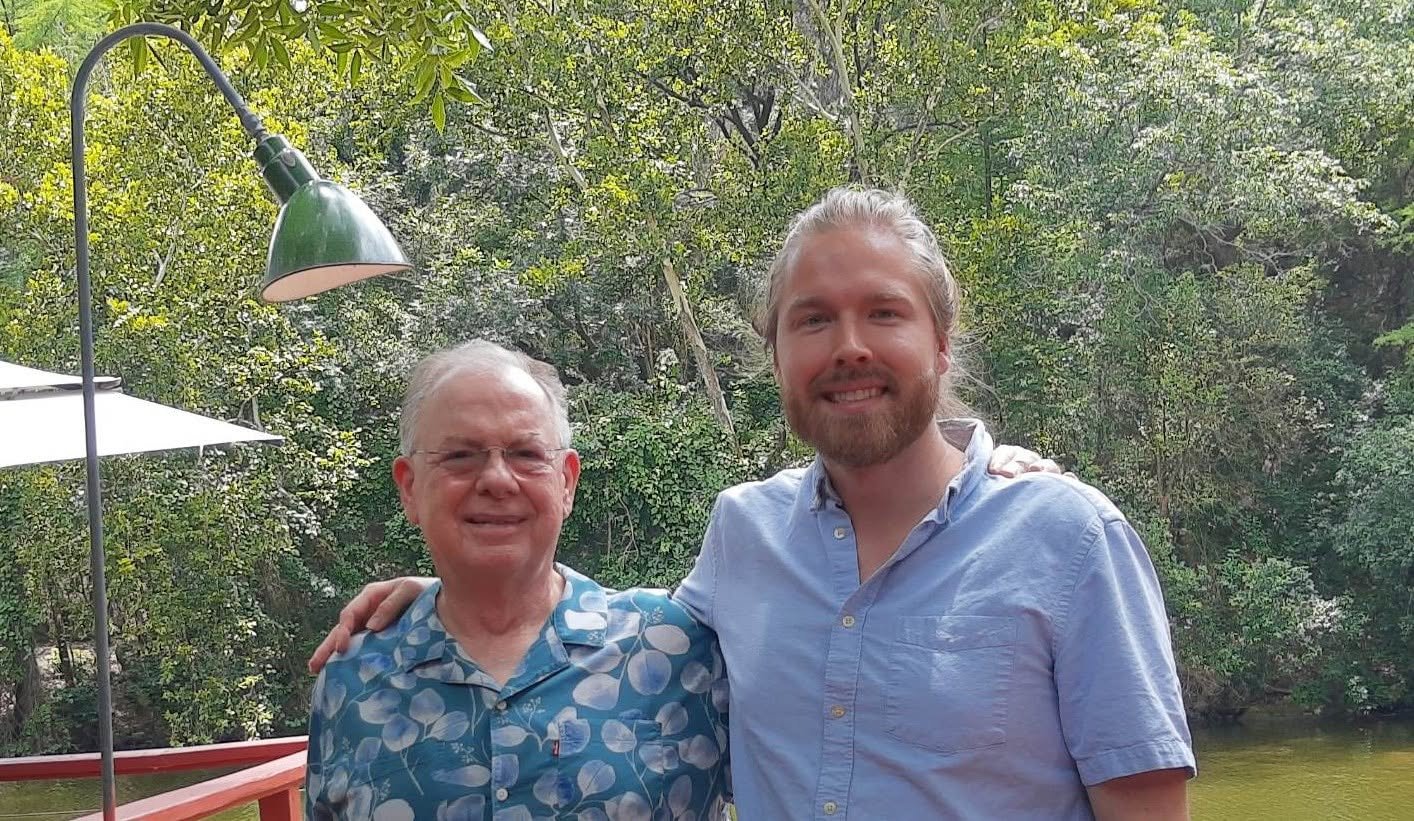 2 men smiling for a photo outdoors in a forested outdoor area - jacob smedley and john rasco