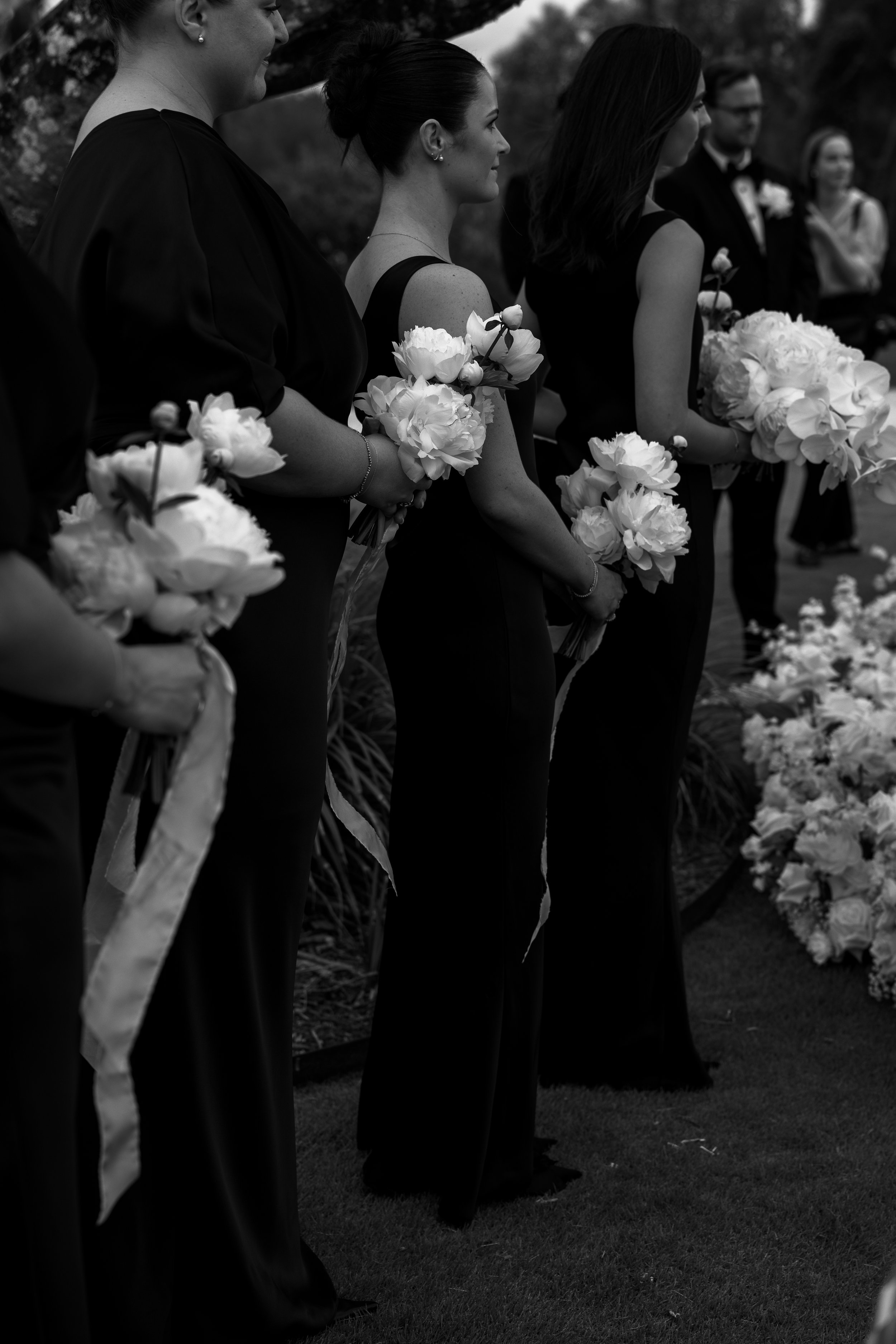 A group of women holding bouquets of flowers during an outdoor wedding. 35mm film wedding photography. Editorial style photography. Gold Coast Australia.
