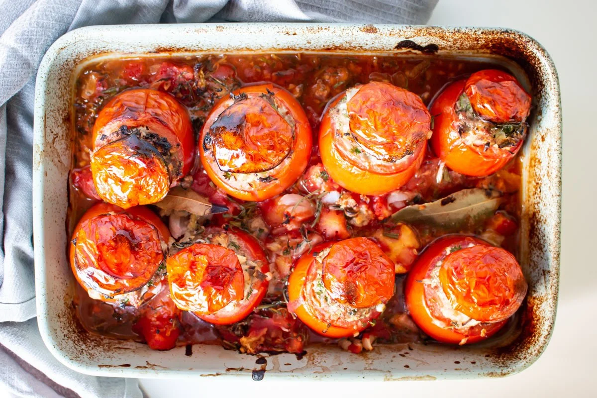 Gevulde tomaten uit de oven, geserveerd in een ovenschaal.