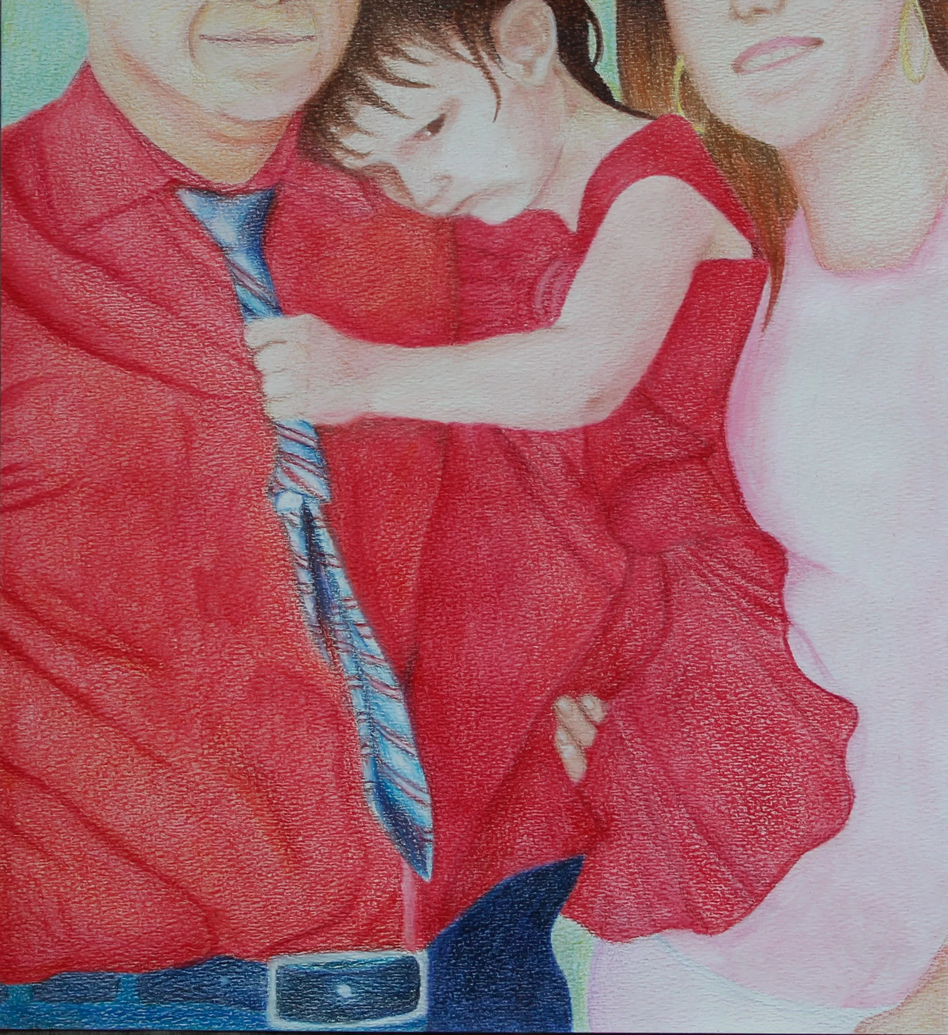 A family portrait featuring a man, woman, and a young girl, all dressed in red, with the girl hugging the man's chest.