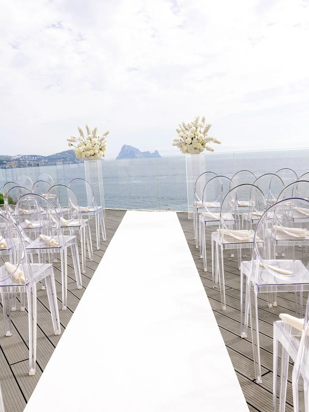 Ghost chairs doing exactly what they were made to do. 

When the ceremony backdrop is this dramatic, every piece of decor should serve a purpose&mdash;or completely get out of the way. 

A huge reward for one simple design change: swapping out the ve