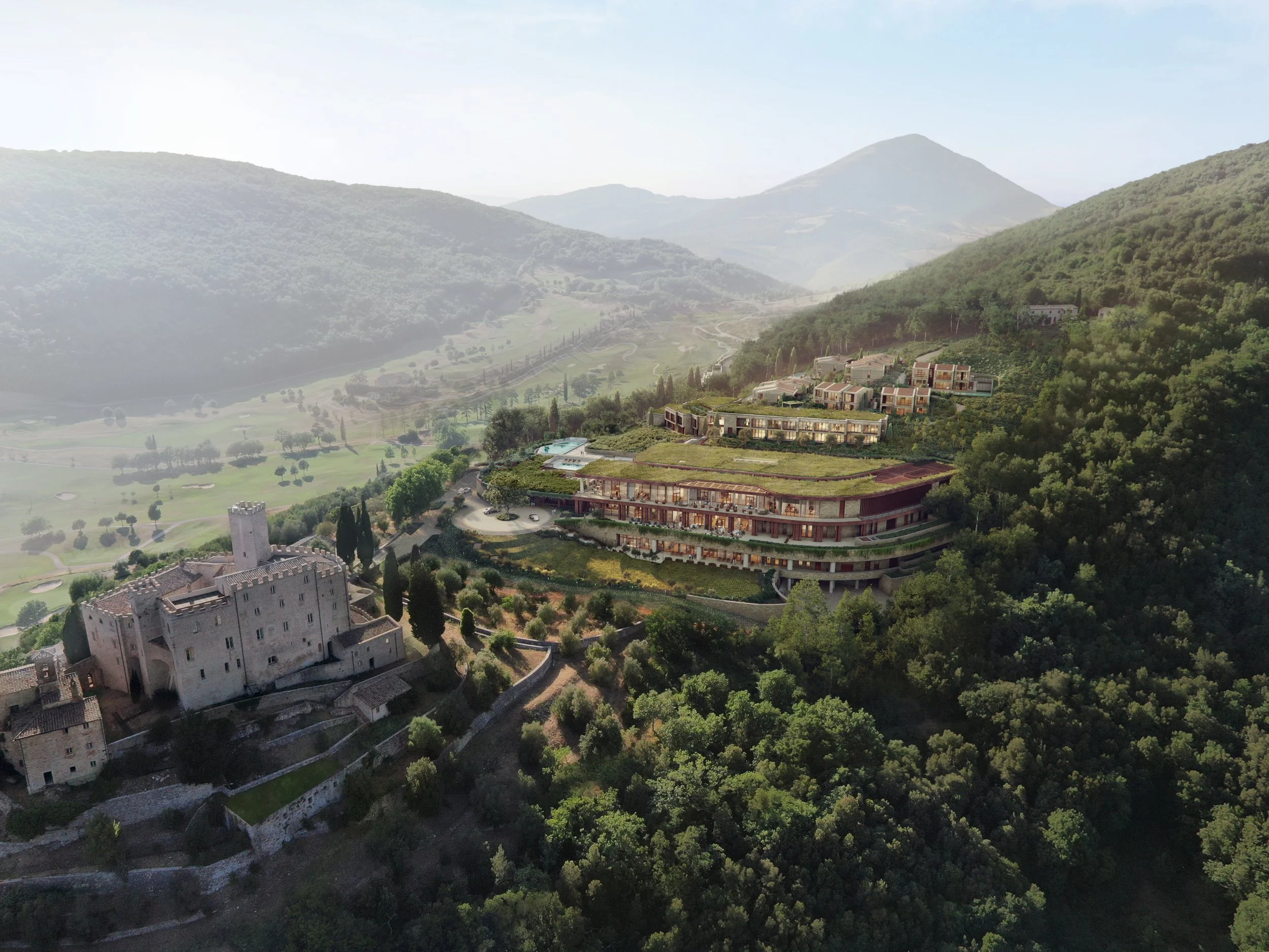 A scenic view of Antognolla castle and Borgo Massarello surrounded by green trees and mountains.