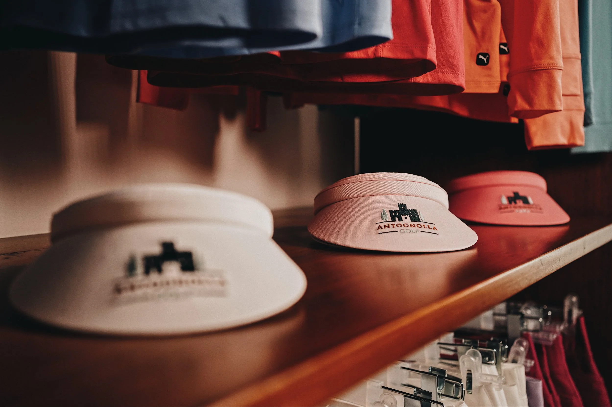 Pink and white golf visors with Antognolla Golf logo
