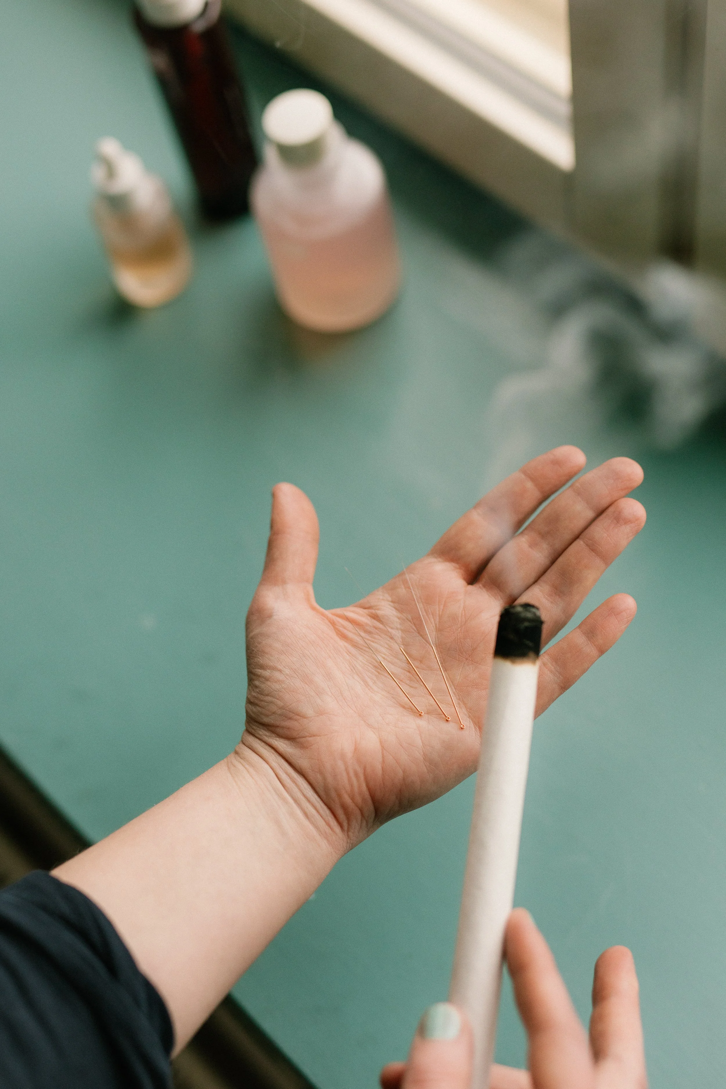 Kämmenessä akupunktioneuloja ja moksa.