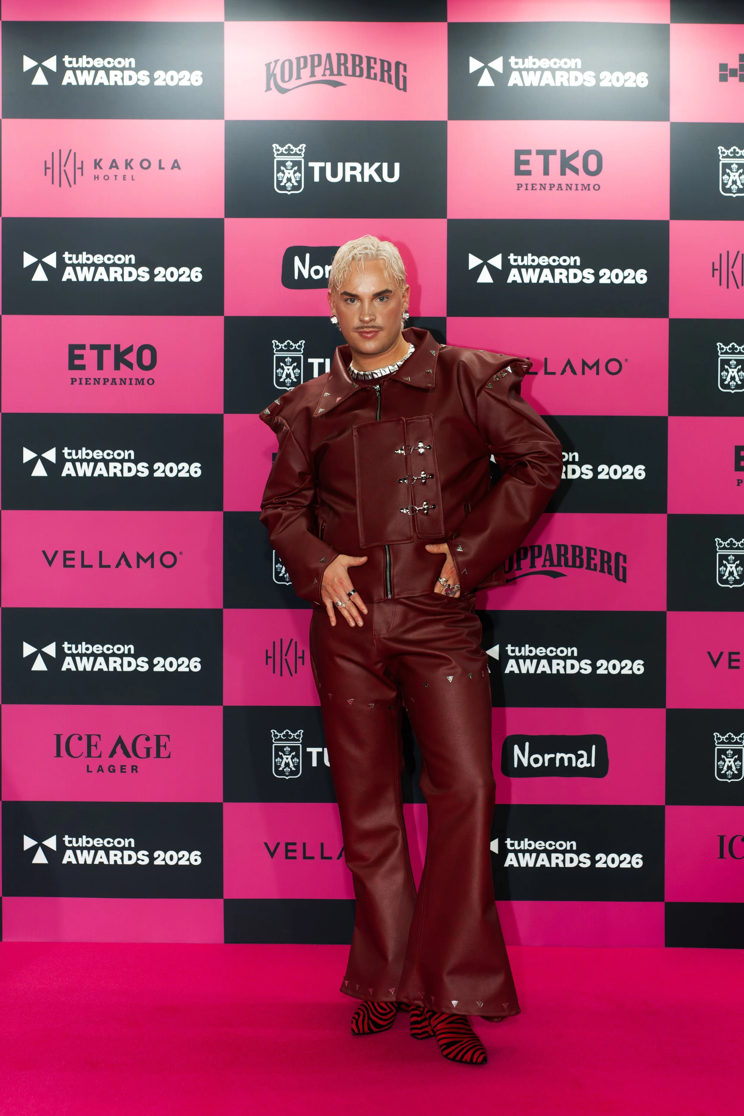 Tubecon Awards punaisella matolla juontaja  Joona Hellman näyttävässä punaisessa nahkaasussa.