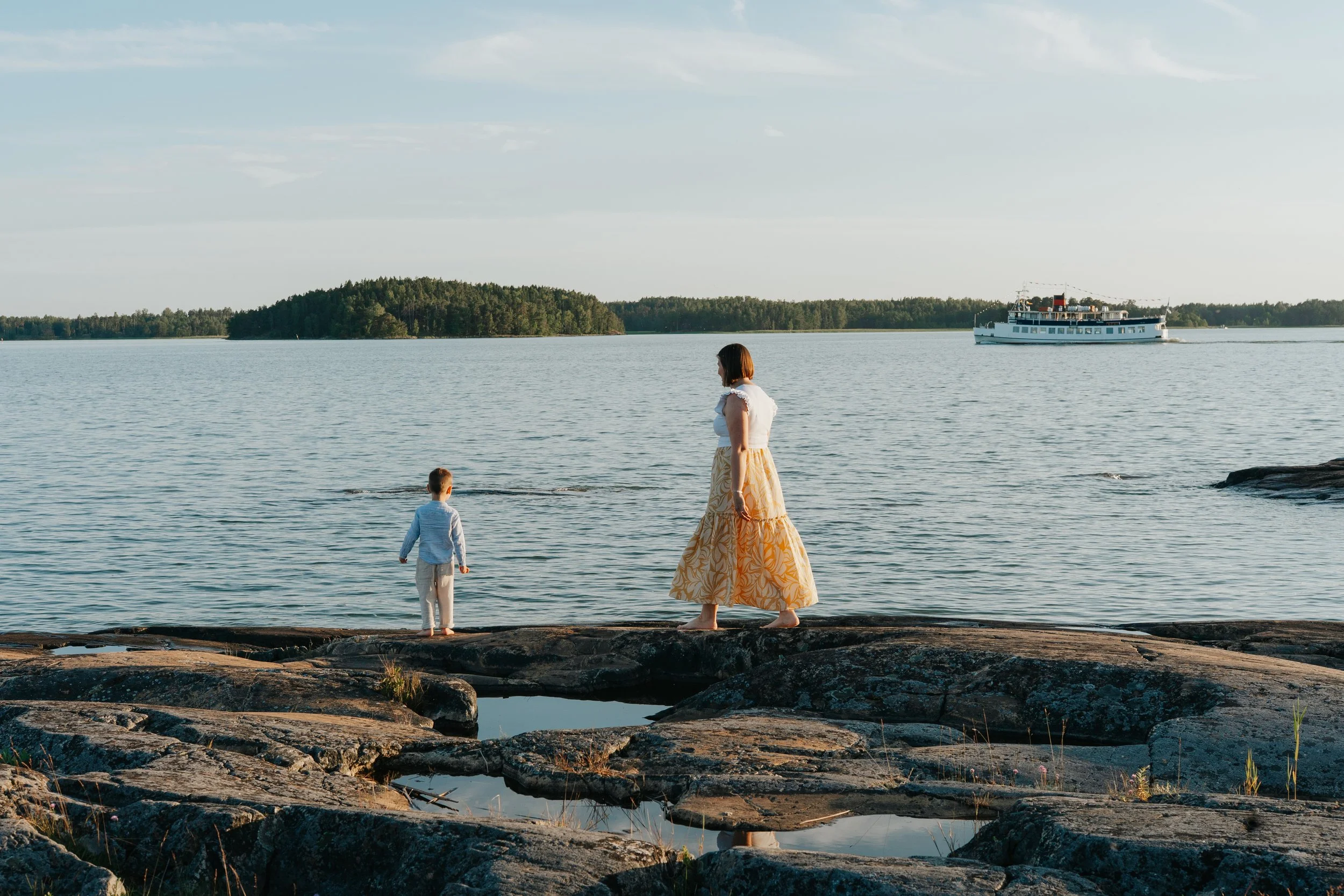 Luonnollinen perhekuvaus Turussa Ruissalon merellisessä miljöössä kesäillassa.