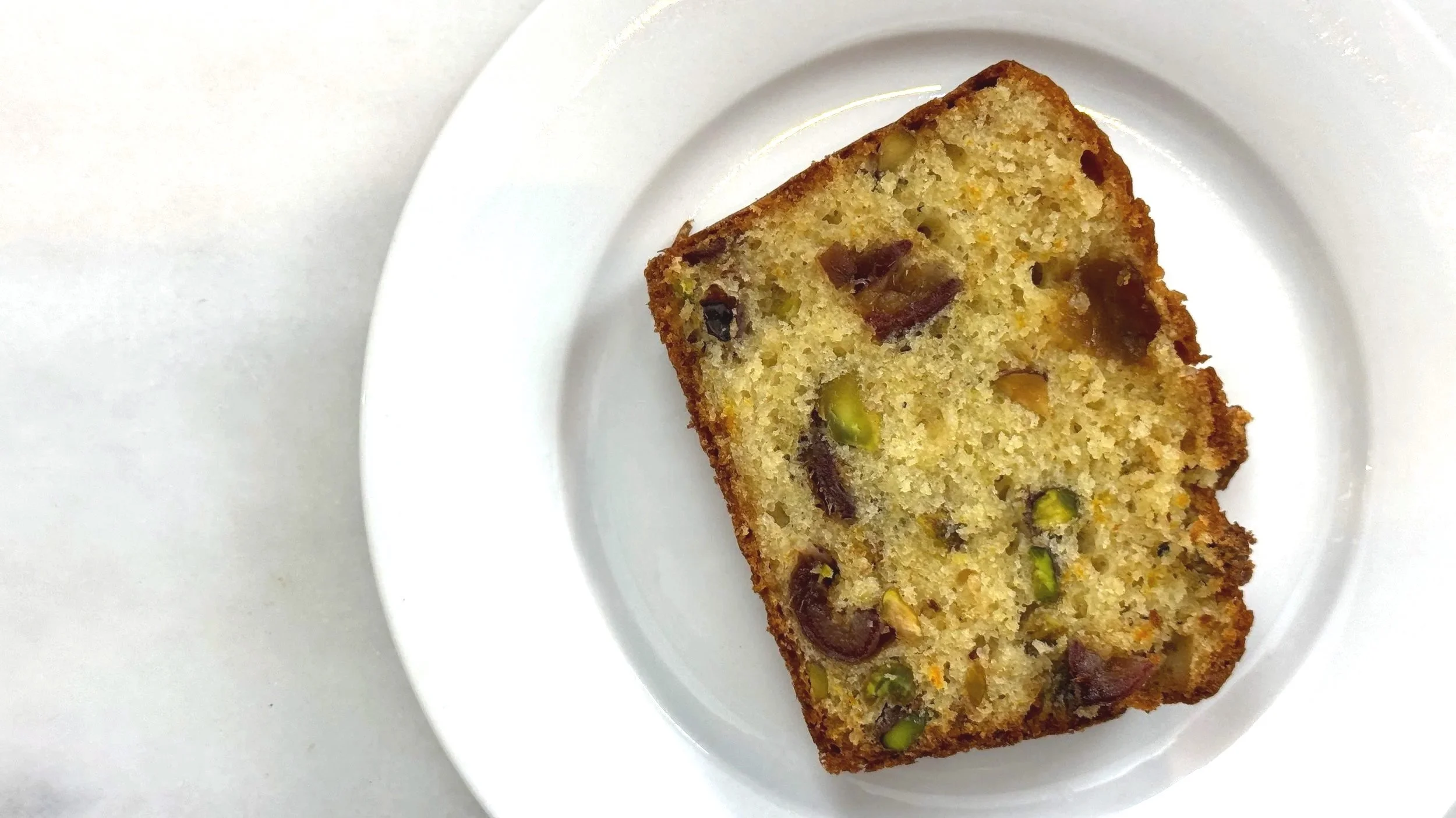 slice of orange pistachio date loaf