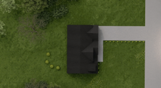 Aerial view of a house with a black roof, surrounded by green grass and trees, with a gray driveway.