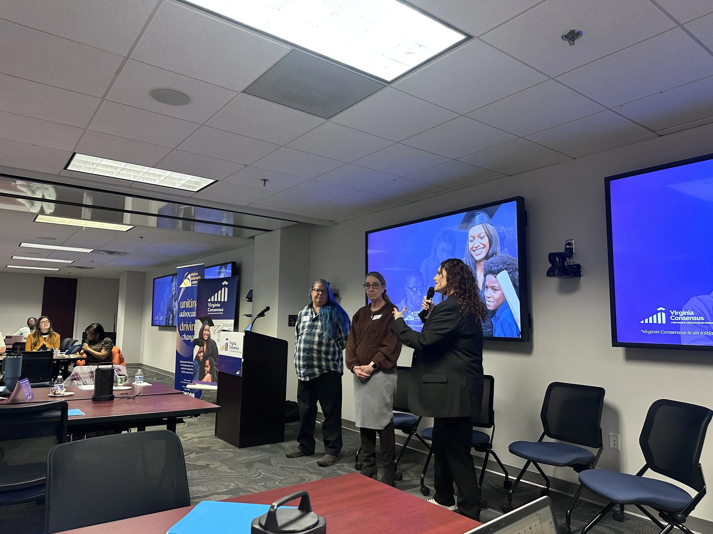 Panelists stand and speak about their experience