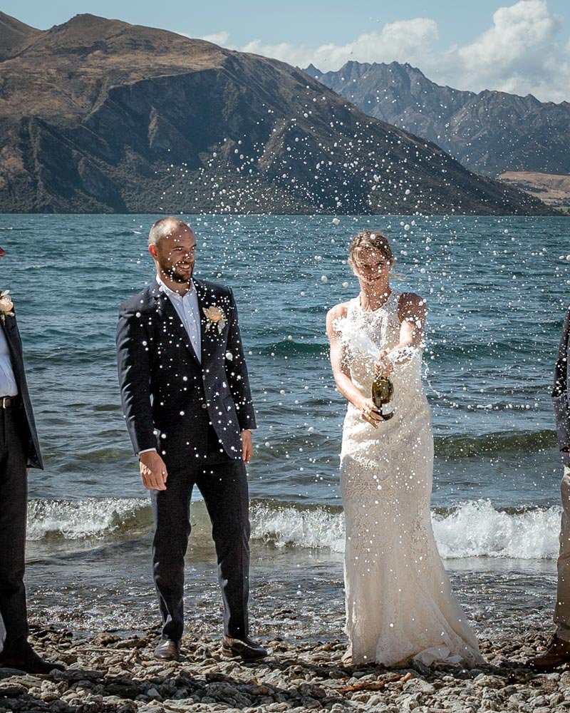 bride popping central Otago champagne to celebrate their elopement in Wanaka