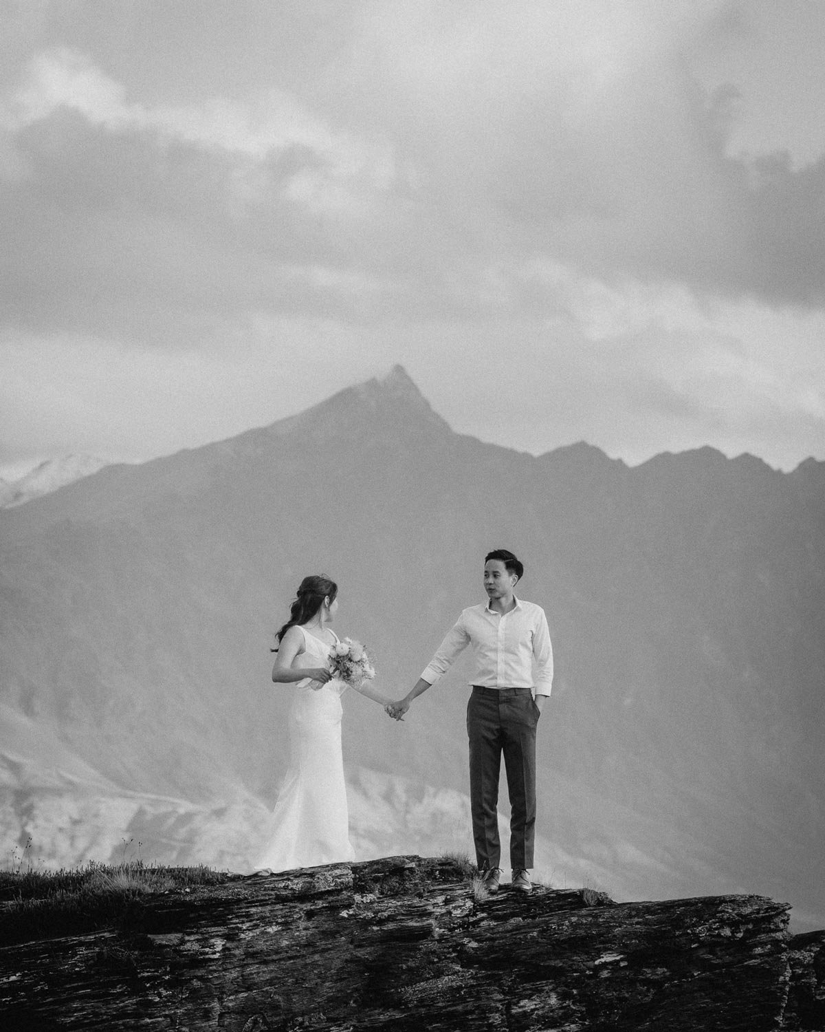 Couple standing on mountain edge holding hands in Skippers Canyon