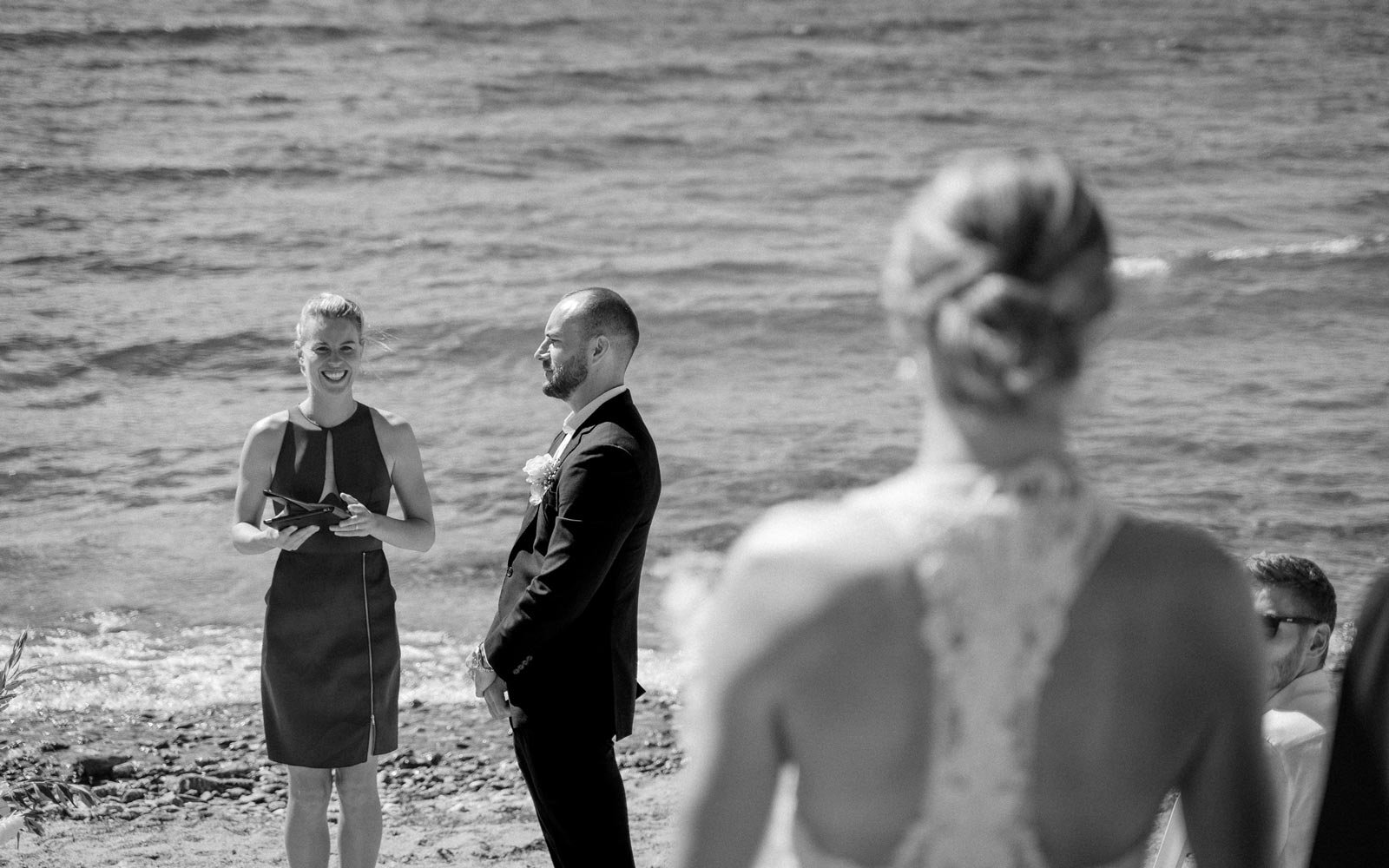 groom and queenstown celebrant wait by the lake for bride to walk down the isle
