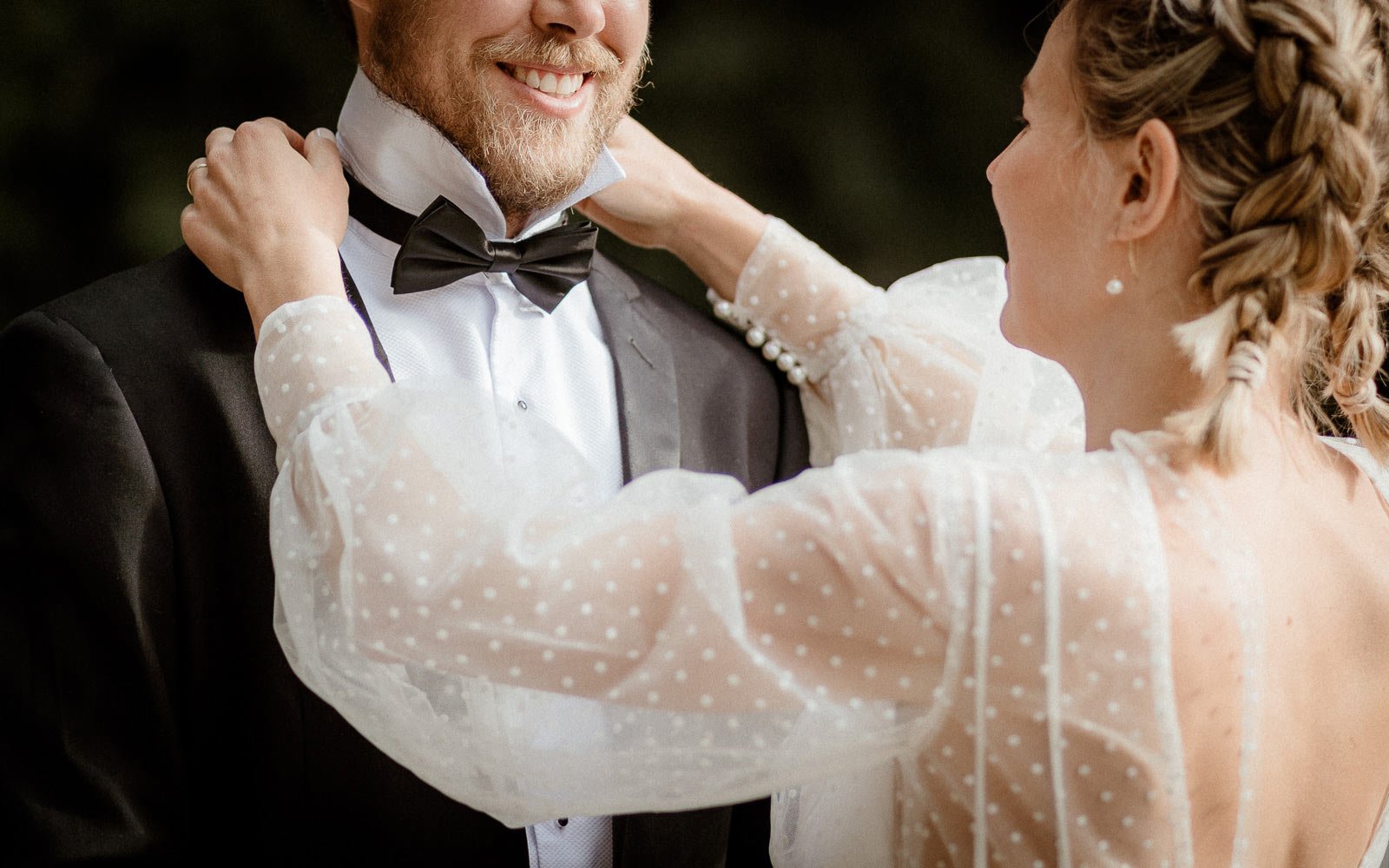 Bride straightening grooms tie before elopement