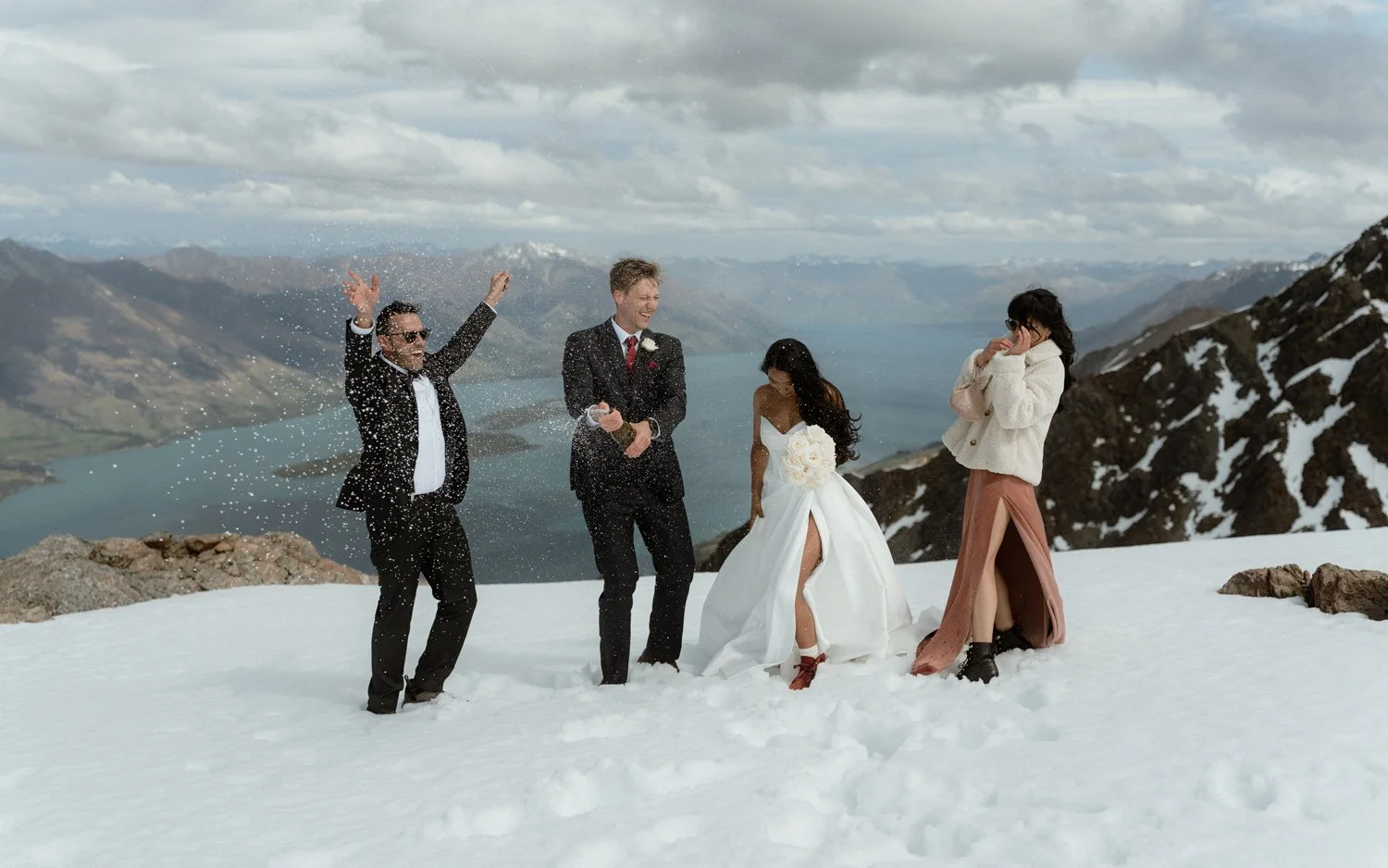 Central Otago champagne pop during NZ heli elopement wedding in Queenstown on the snowy humboldts mountains near Glenorchy.  