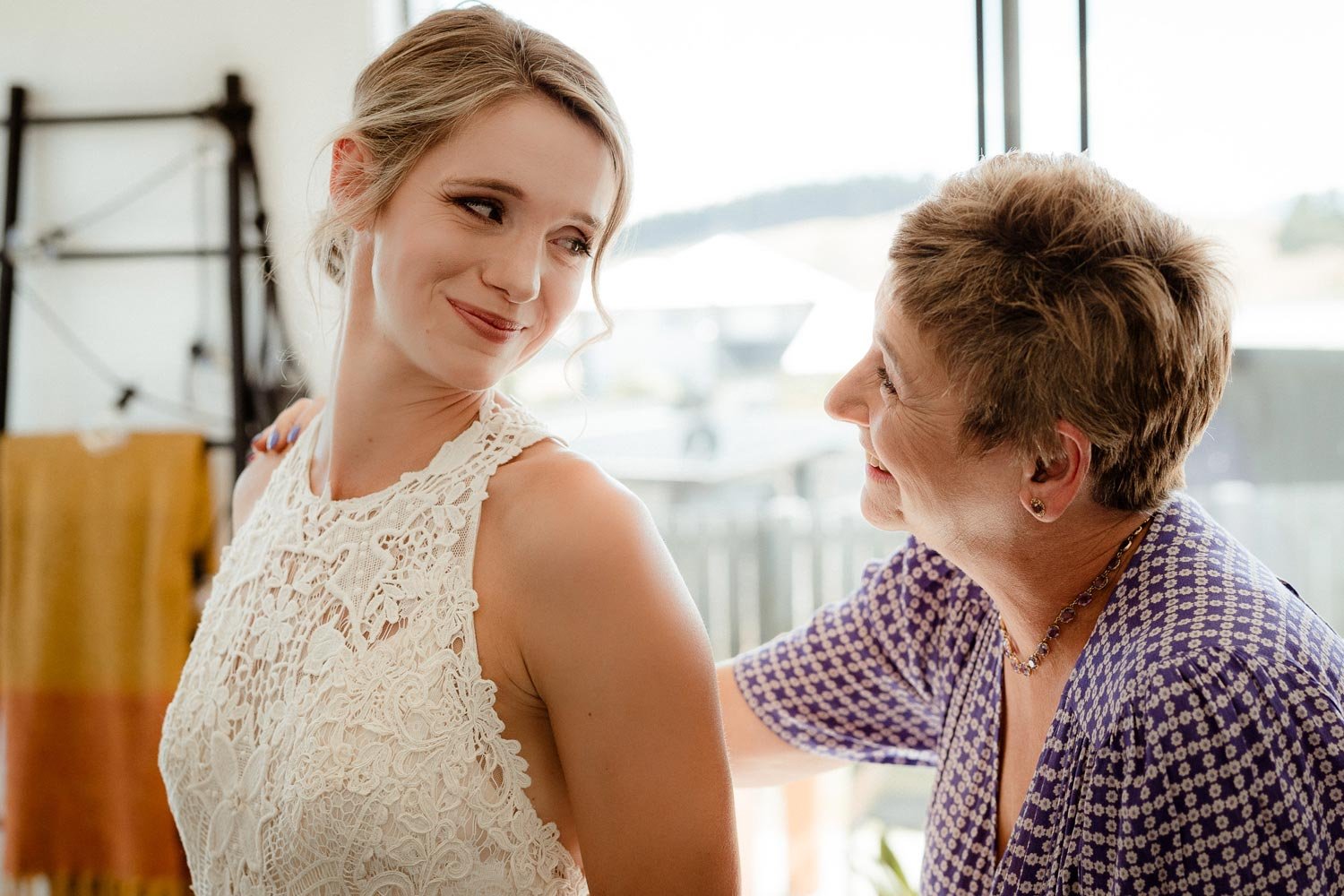 bride in stunning dress crying with her mum while getting ready for her wedding