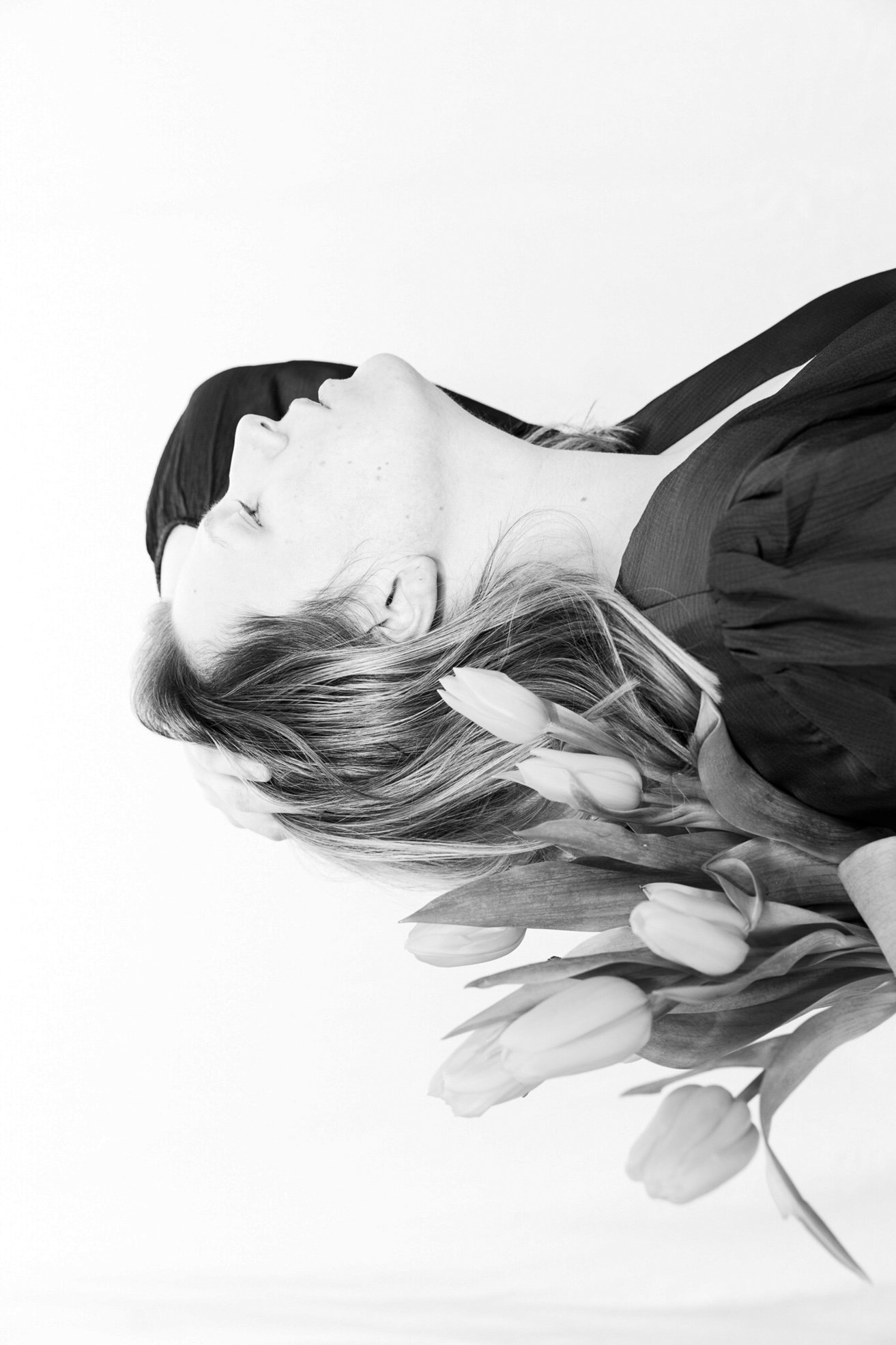 Frau mit geschlossenen Augen, Tulpen im Haar – ästhetisches Studiofoto