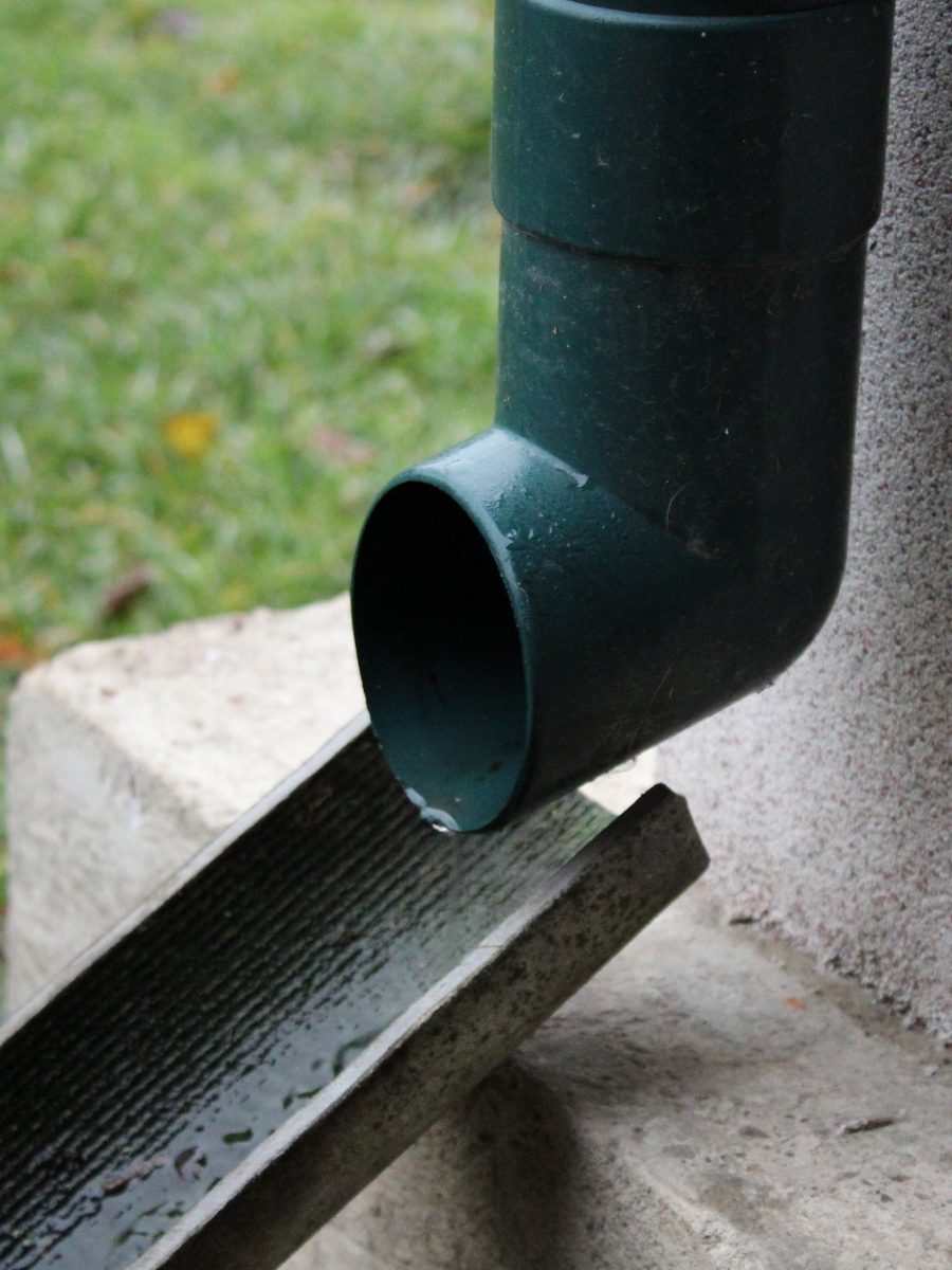 Downspout directing rainwater onto a drainage splash block