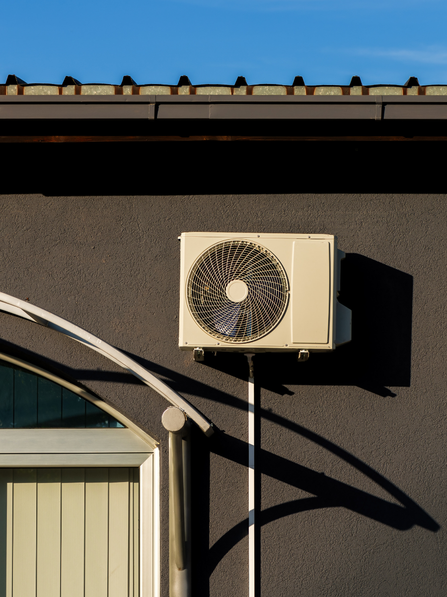 Outdoor mini-split condenser mounted on an exterior wall