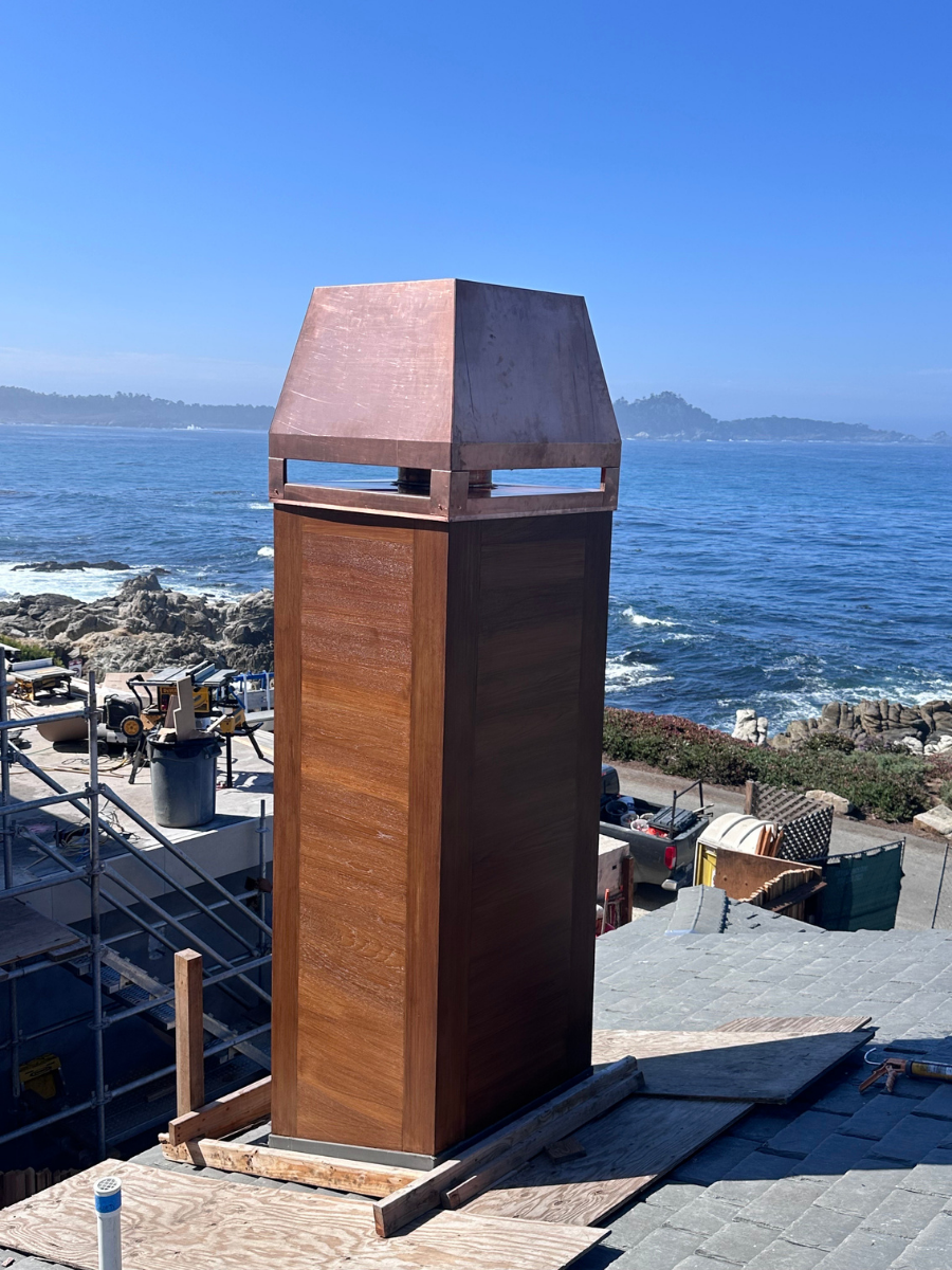 Custom copper chimney cap installed on a coastal roof