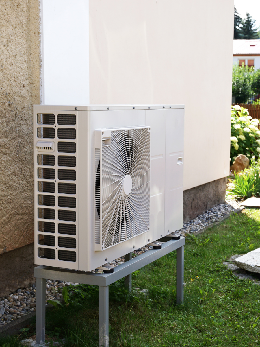 Outdoor heat pump installed on a raised equipment stand