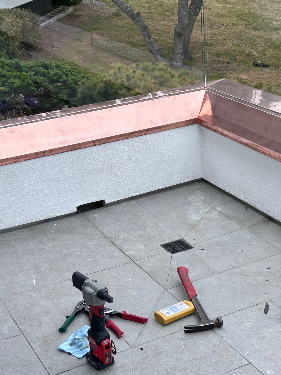 Custom copper parapet cap flashing during installation
