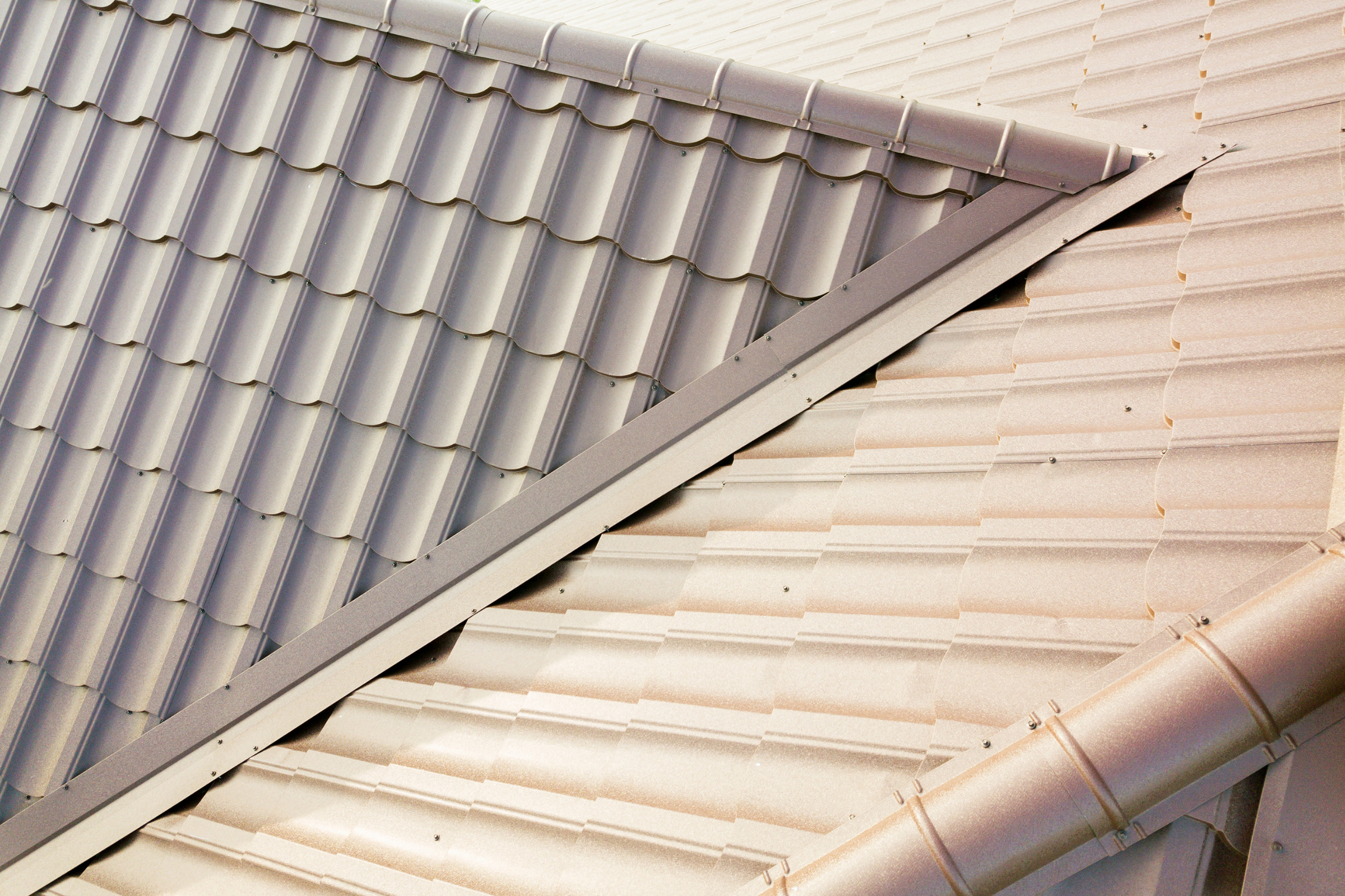 Metal tile roofing system featuring custom valley flashing and matching metal gutters