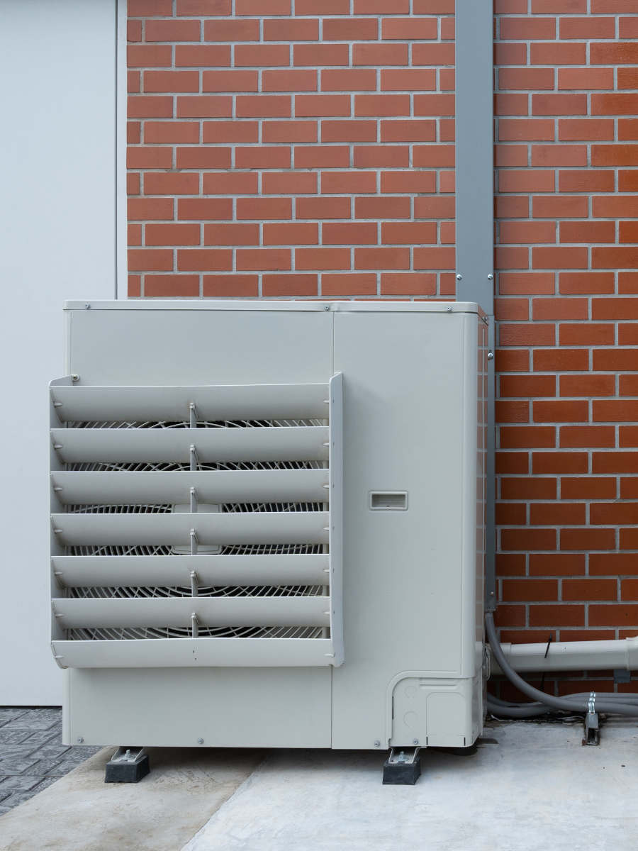 Large commercial HVAC condenser installed outside a brick building