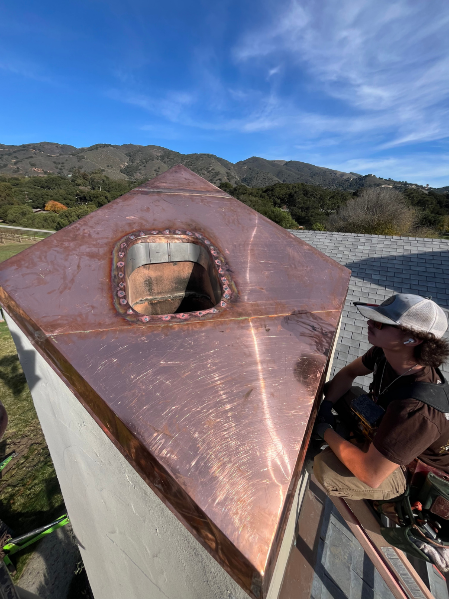 Sheet metal technician installing custom copper chimney flashing