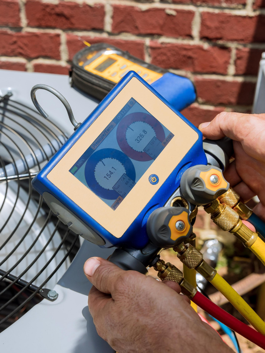 Technician using digital gauges to diagnose an air conditioning system