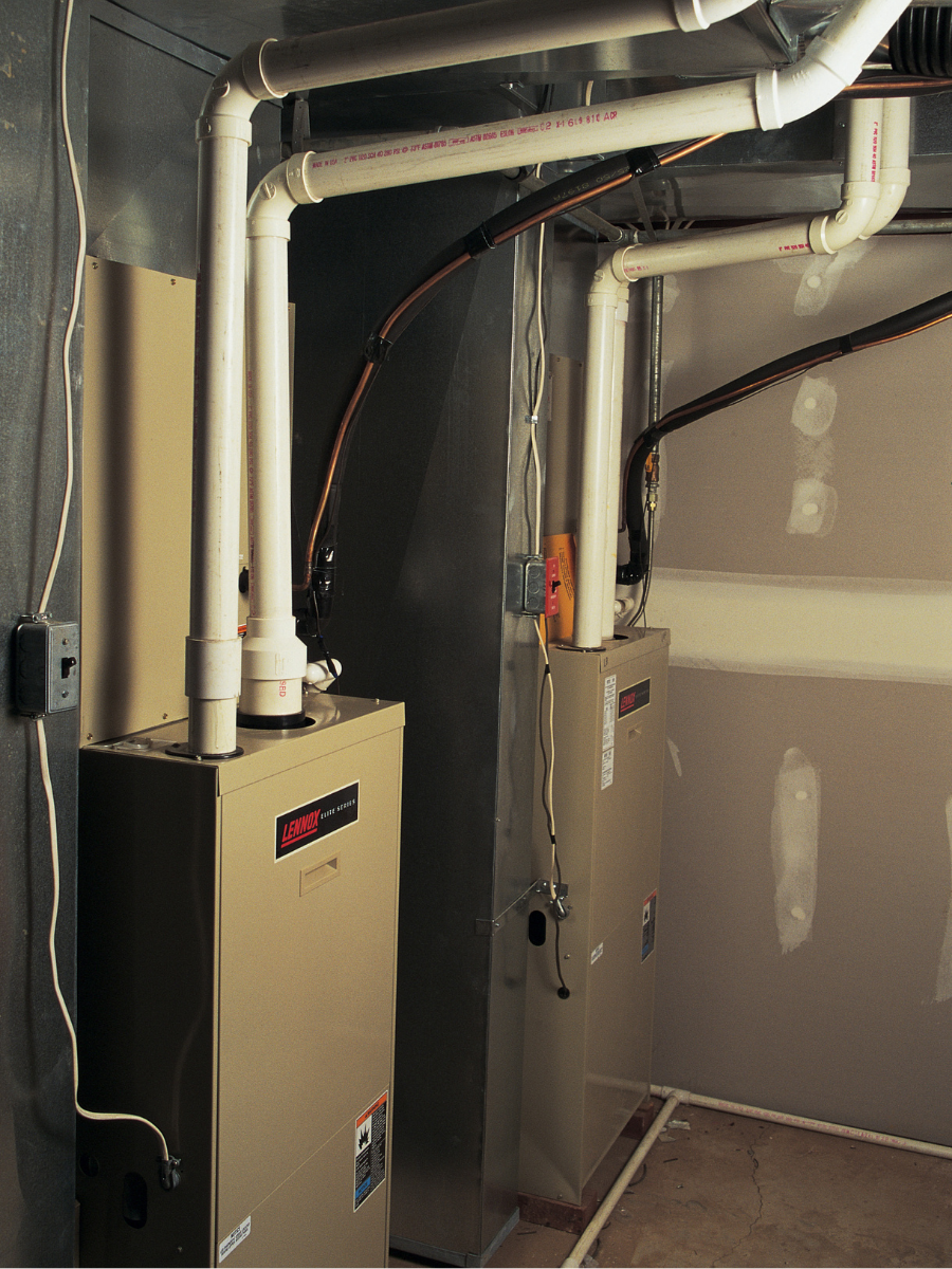 Two high-efficiency gas furnaces connected to residential ductwork and venting