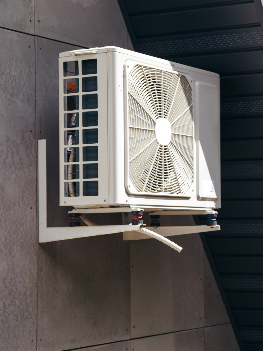 Outdoor ductless mini-split condenser mounted on an exterior wall