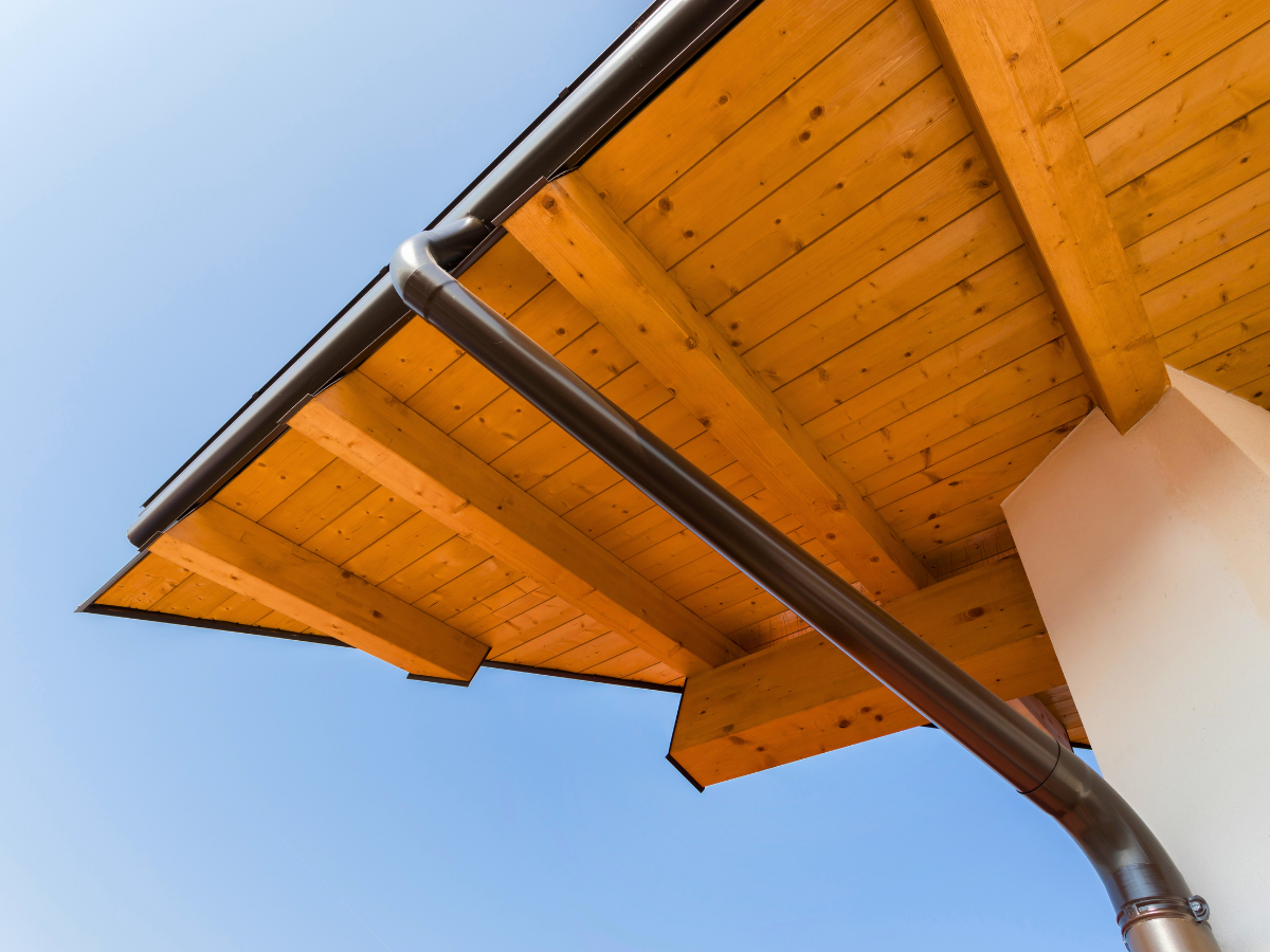 Metal gutter and downspout installed along a residential roofline