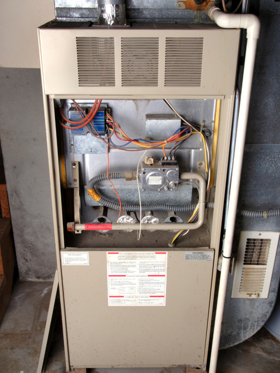 Older residential gas furnace with access panel removed Keep