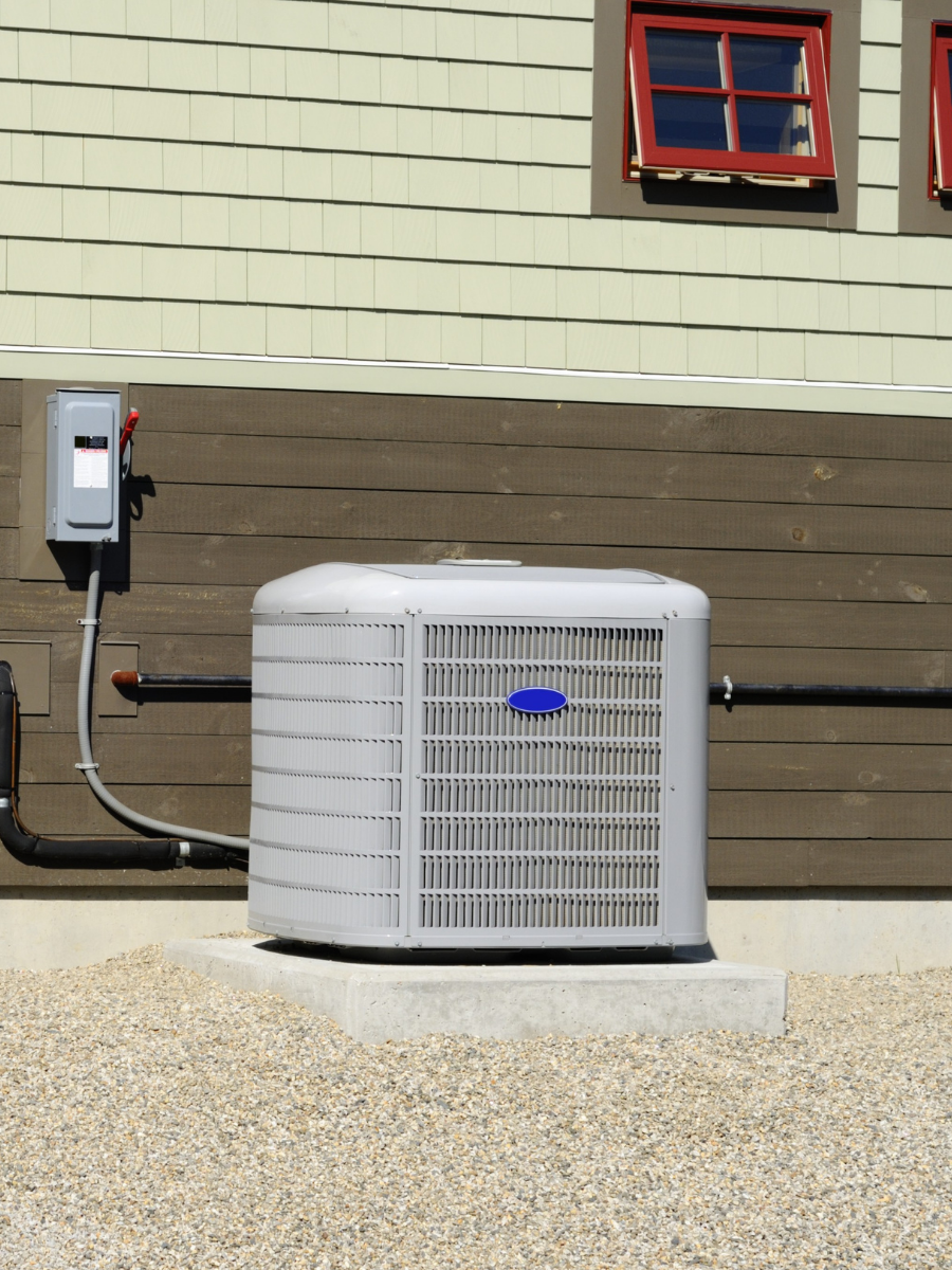 Residential air conditioning condenser installed beside a home